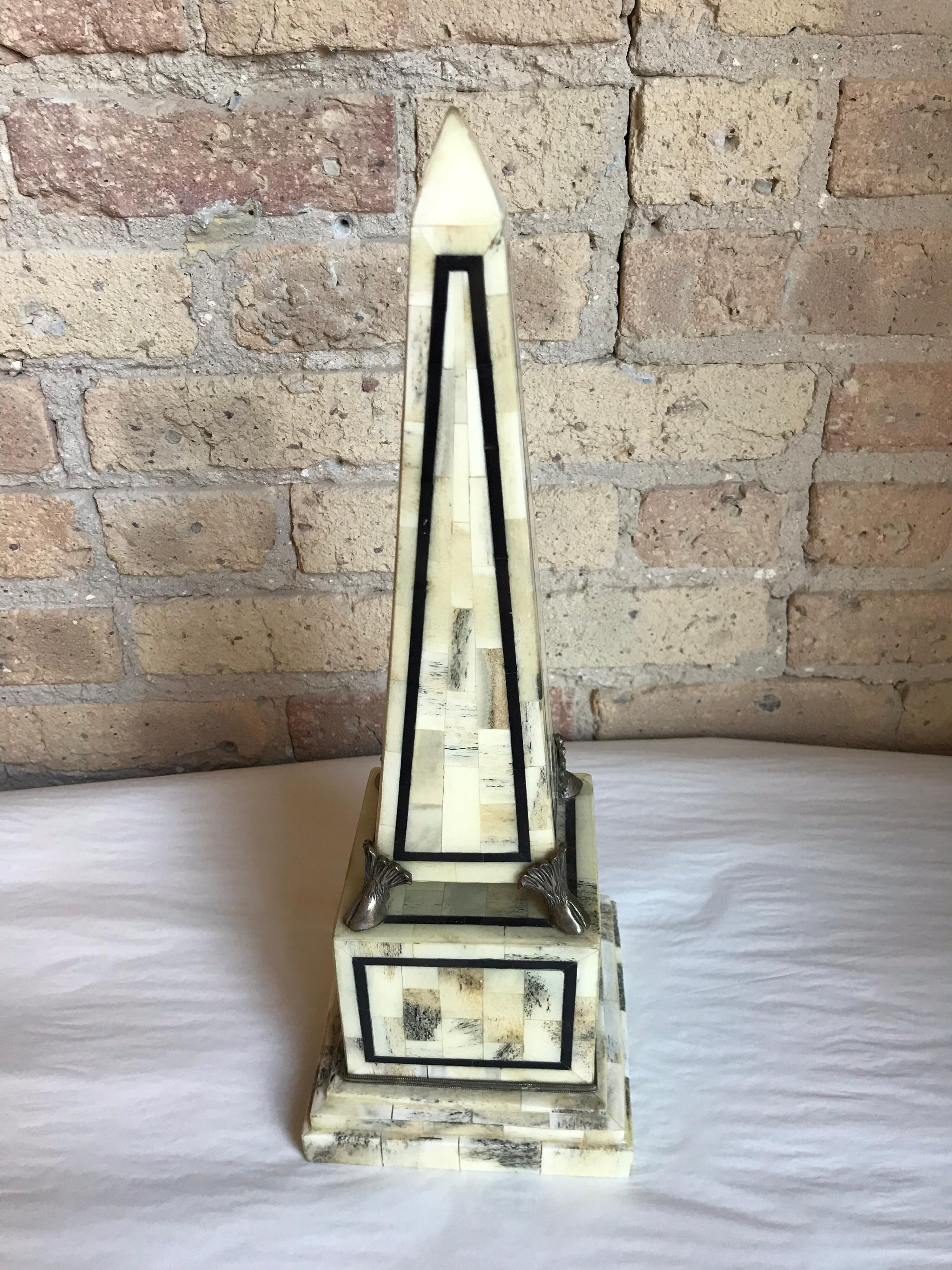 This is a pair of off-white bone and silver hoof obelisks made by Maitland Smith.