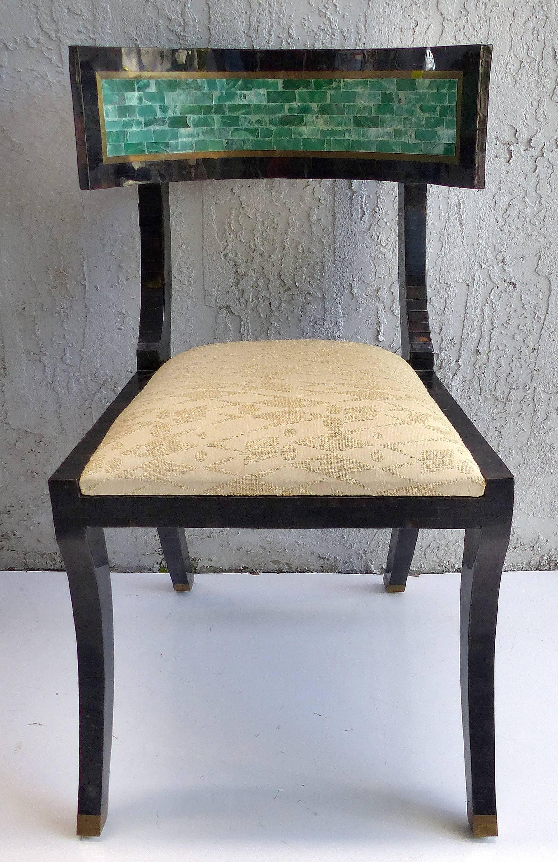 Offered for sale is an elegant and sensual Mid-Century Modern Klismos chair from Maitland-Smith clad in tessellated horn with tessellated stone on the backrest. The entire chair is covered in the horn tiles and the curved backrest has tessellated