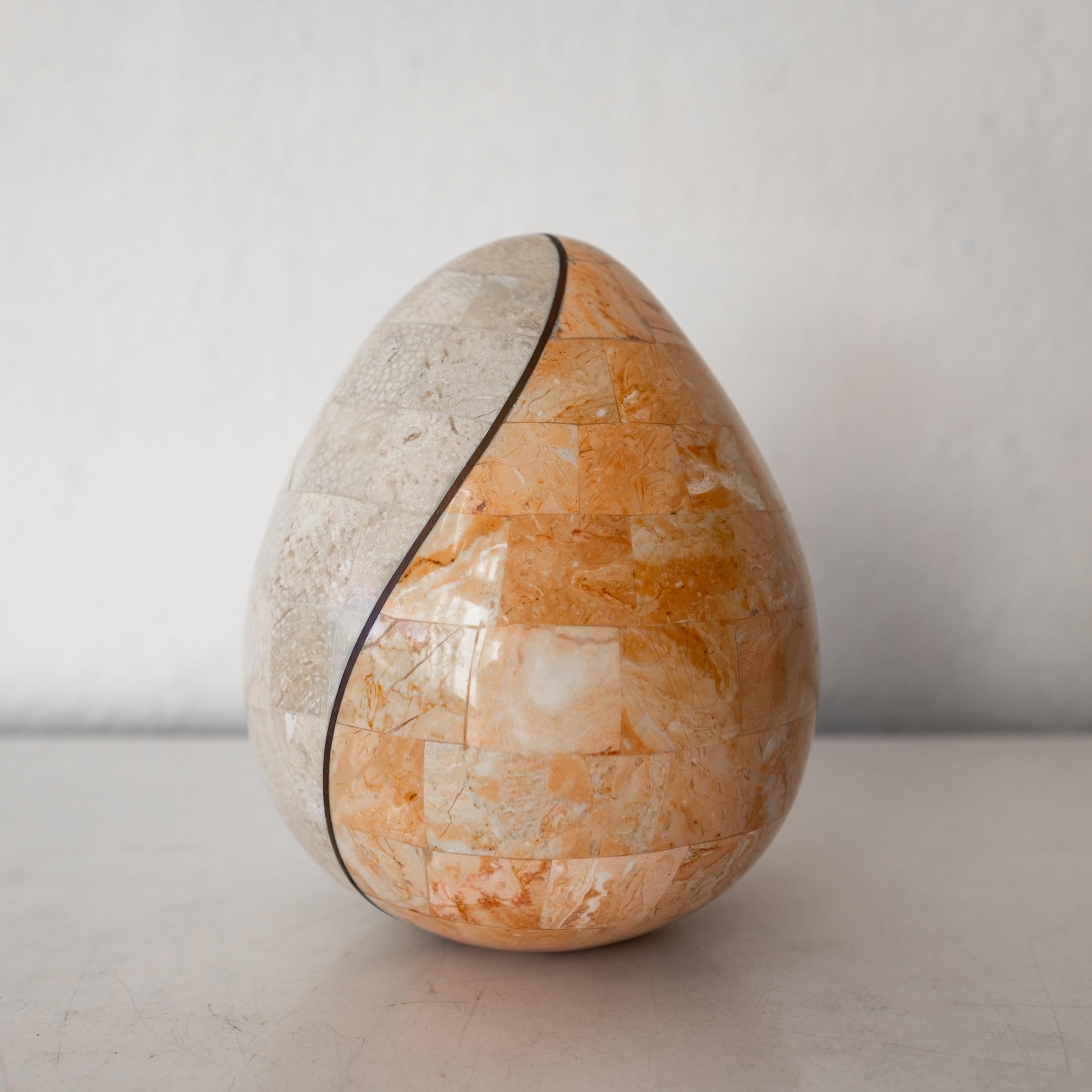 Maitland Smith tessellated stone and brass oval egg form sculpture. The bottom has a flat spot so it stands upright on its own. 