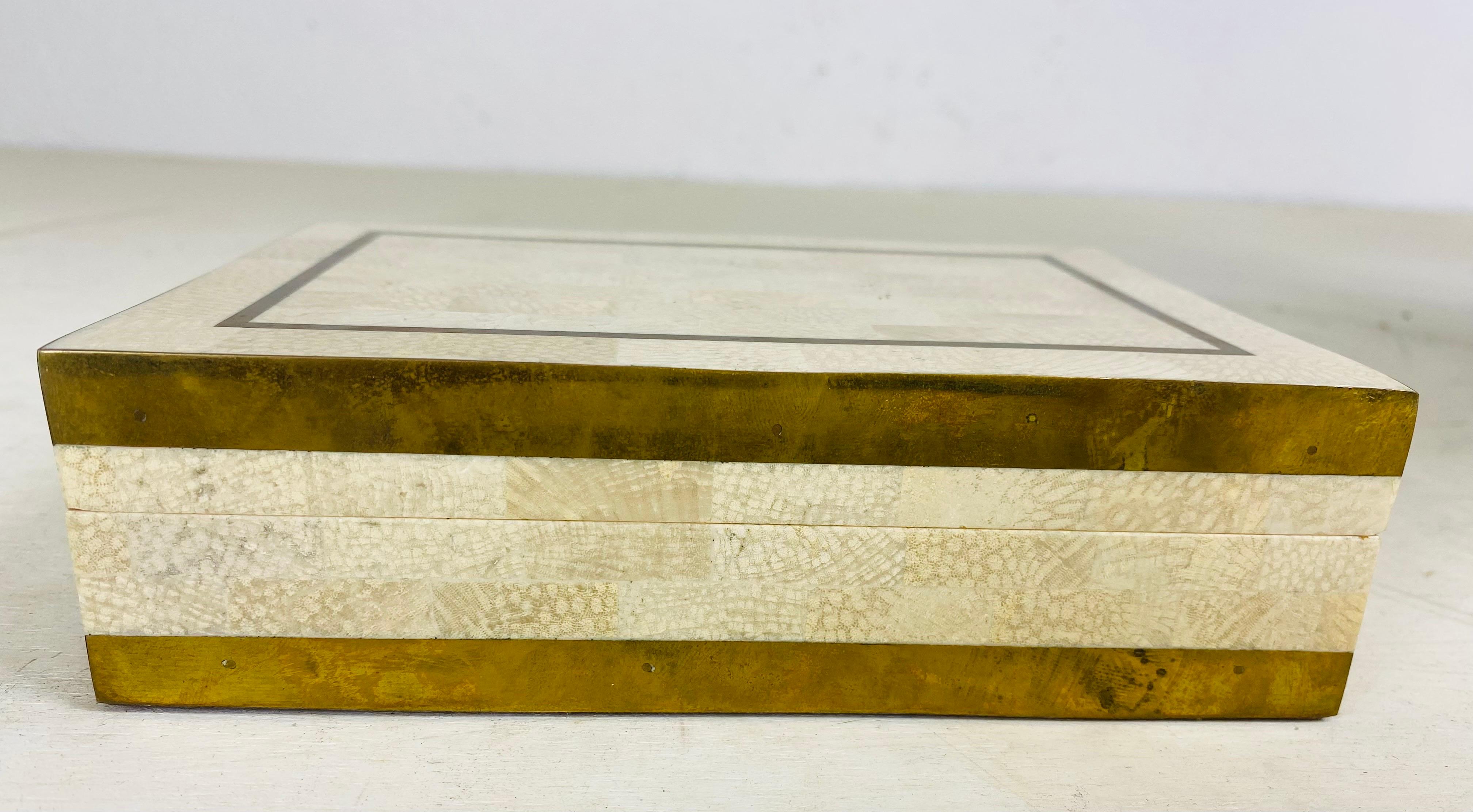 This is a handmade box by Maitland smith. This box is tessellated polish coral with brass trim. This box has a polished teak interior and has its original Maitland Smith tag on the other side.