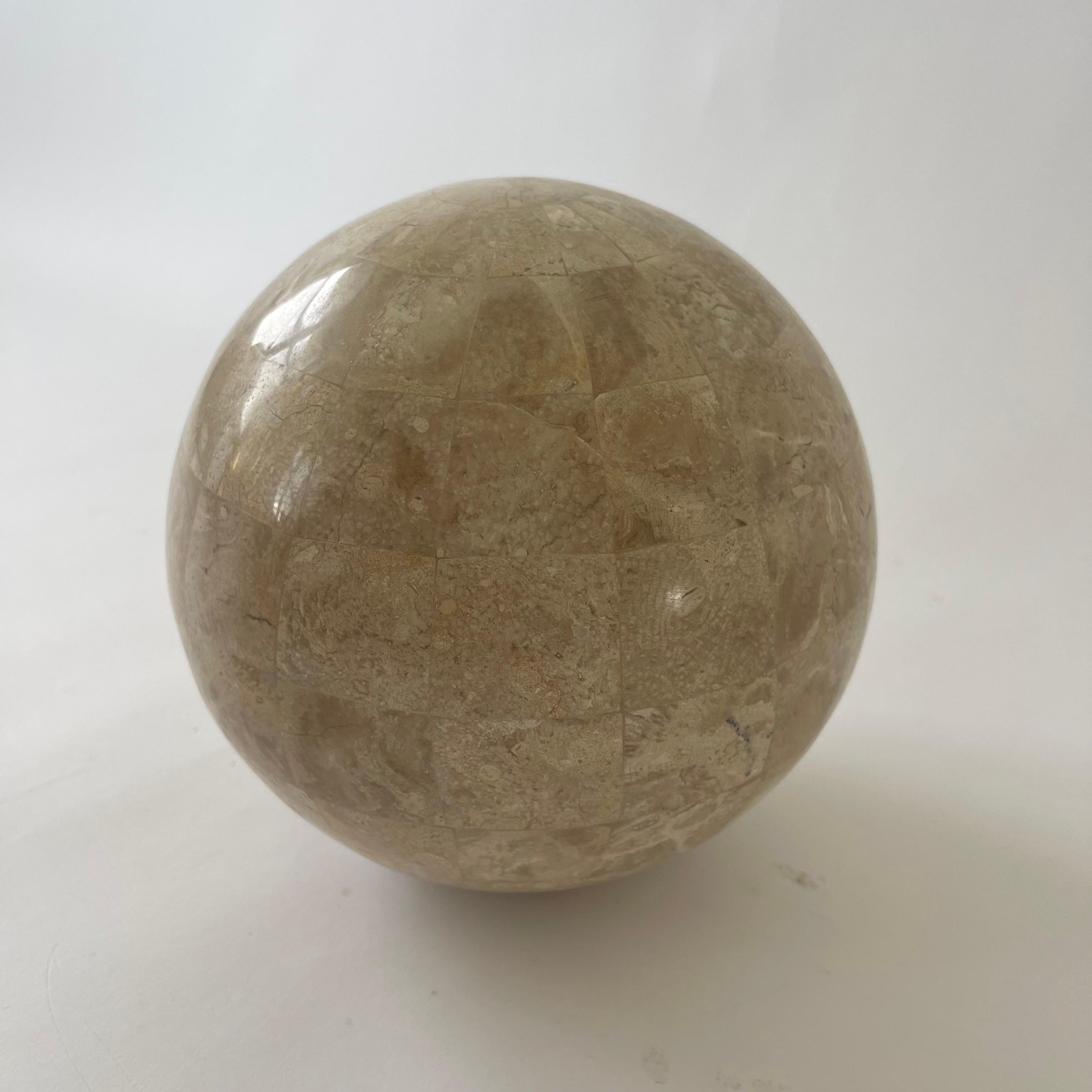 Sphère sculpturale moderne, idéale comme objet d'art sur une étagère ou une table basse.  Réalisé en pierre de travertin tessellée et incrustée, par Maitland Smith.  Philippines, années 1980