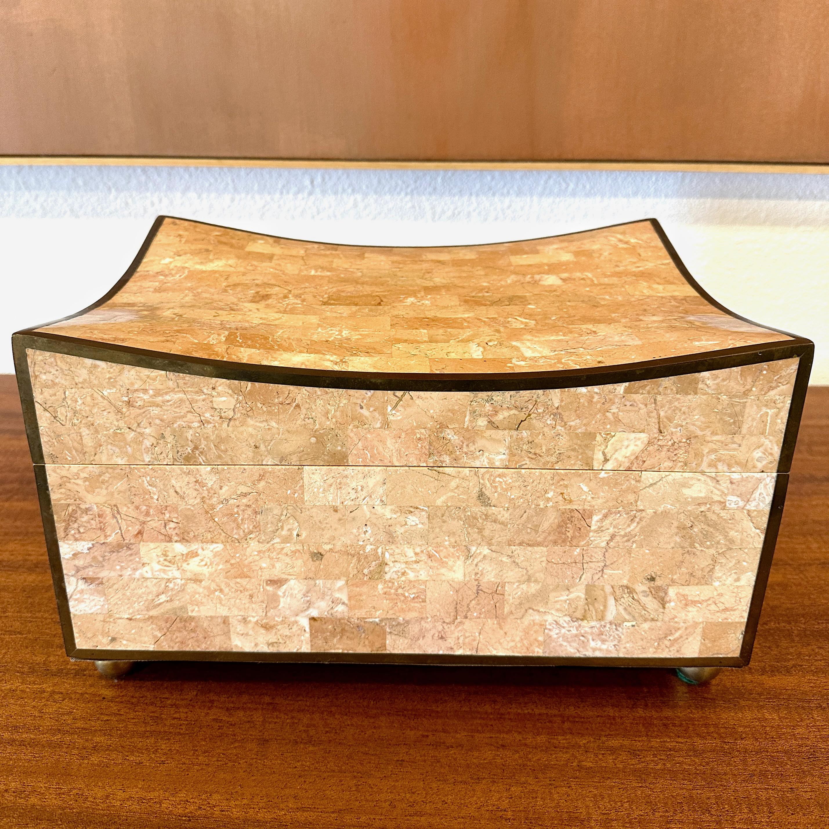 Boîte inhabituelle en marbre rose tessellé de Maitland Smith, vers les années 1990.

Ce coffret rectangulaire est revêtu d'un beau marbre rose tessellé et rehaussé d'une incrustation de laiton sur toute la surface des bords, qui a vieilli pour