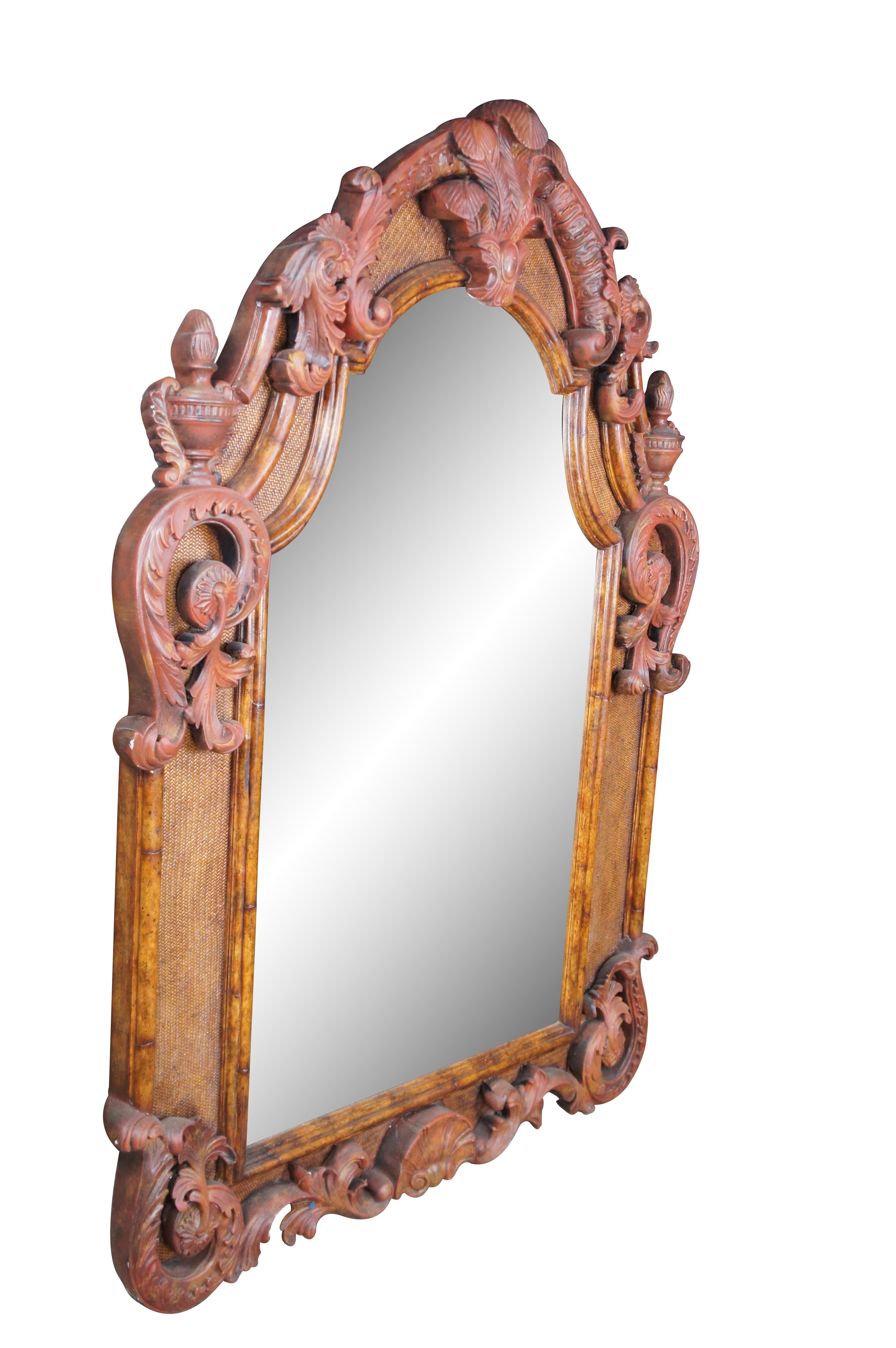 A stately Baroque Rococo style wall hanging mirror by Maitland Smith, circa last quarter 20th century.  Made from walnut with a rattan backing and ornate low relief painted embellishments.  Features an arched crown centered by Prince of Wales