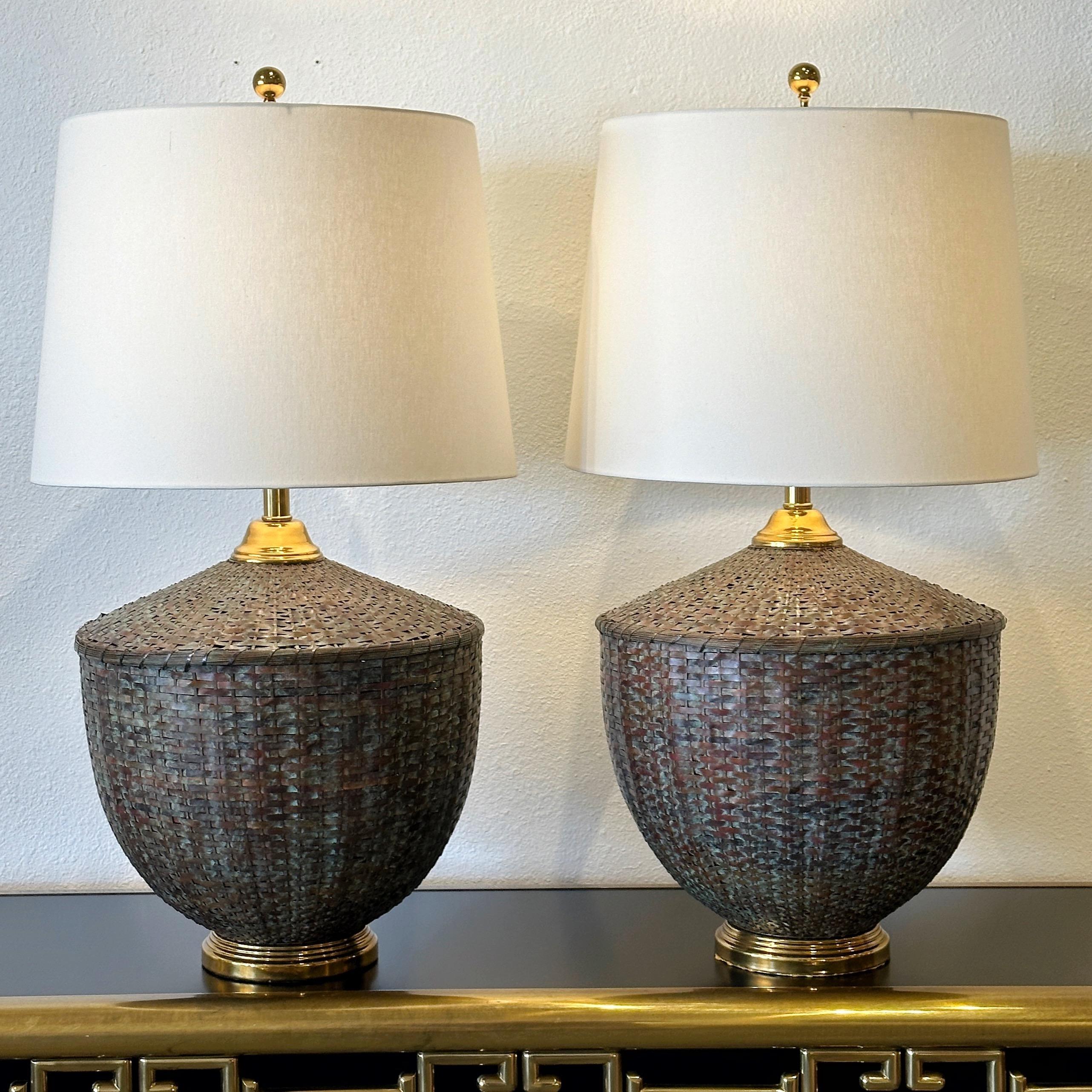 Maitland Smith Woven Patinated Copper and Brass Table Lamps ca 1970s

Beautiful woven patinated copper lamp base in a basket form with circular stepped brass base and brass ball finial. This is a transitional modern design that can fit in with many