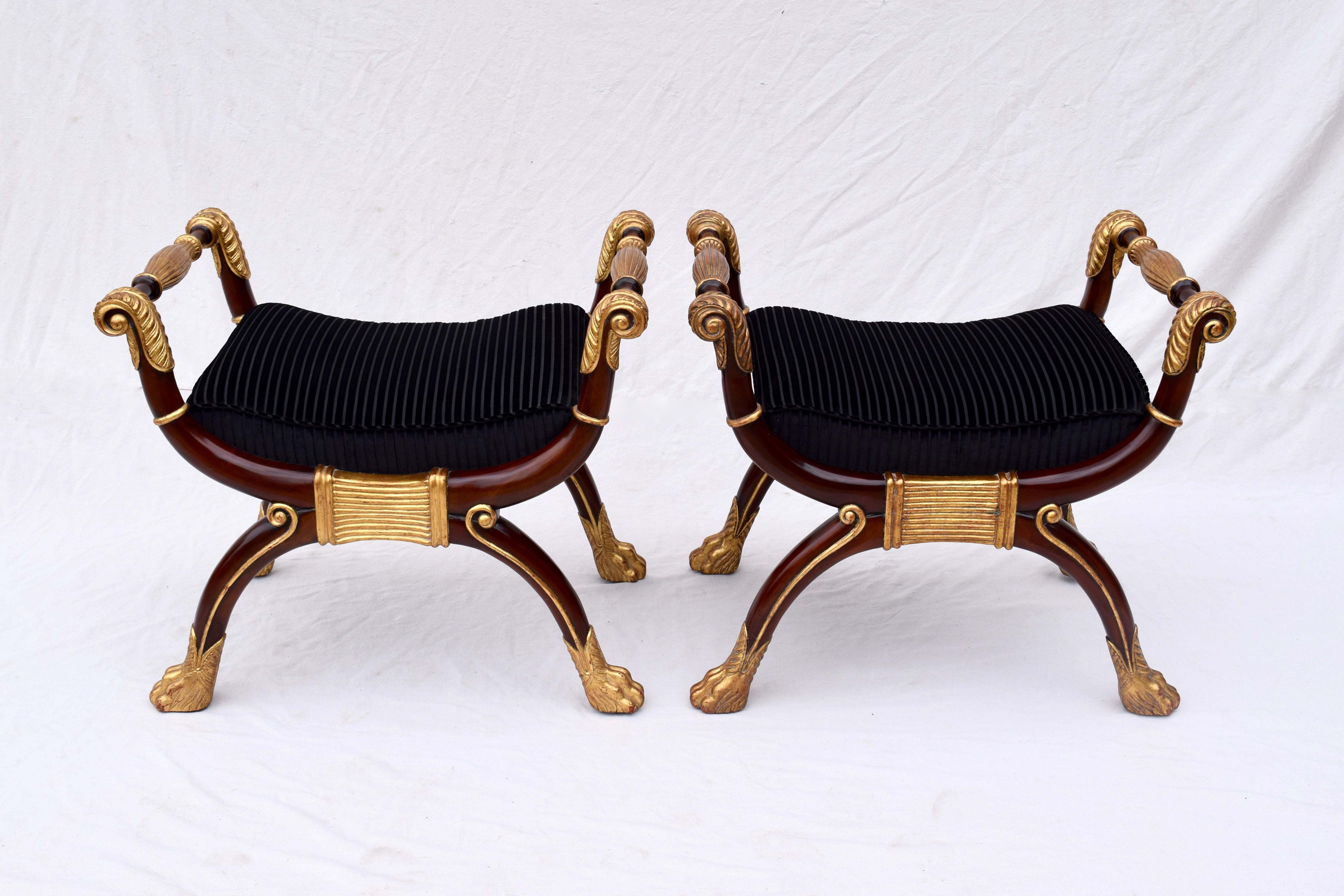 A striking pair of Maitland Smith mahogany and gold gilt benches with carved scroll arms, newly upholstered striped velvet seats and curule, claw foot bases.
Measures: Seat height 19.5
