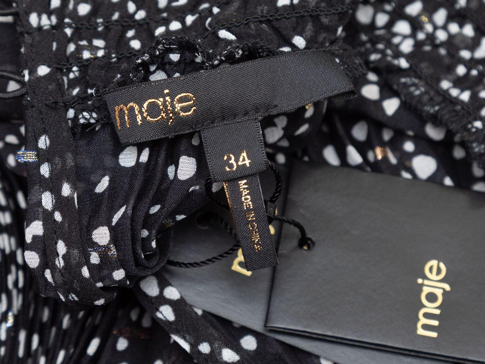 Product Details: Black and white silk polka dot print mini dress by Maje. Crew neck. Long sleeves. 50