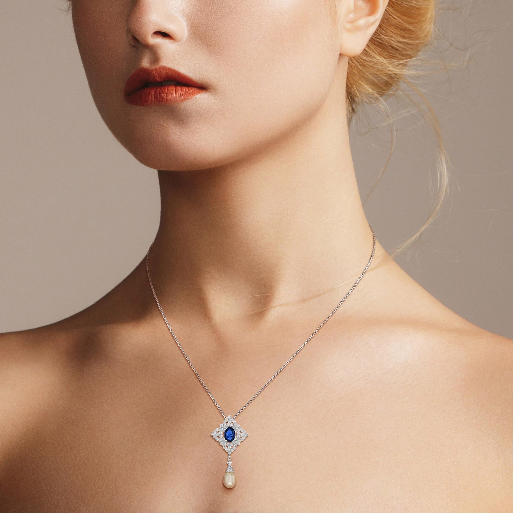This stunning drop pendant features a luminous natural pearl and deeply hued blue sapphire surrounded by 51 round diamonds in brilliant detail. Both are set in 18k white gold.

Pendant Information
Metal: 18K White Gold
Width: 20 mm.
Length: 39