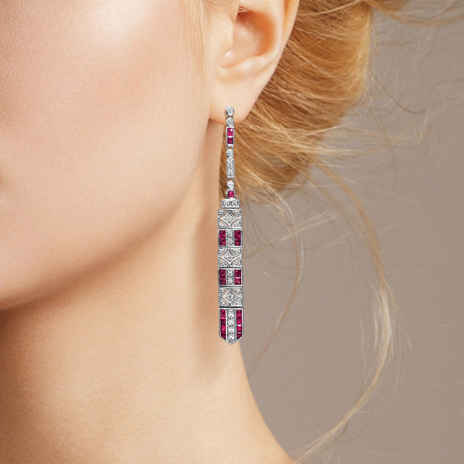 These art deco bar dangle earrings are the epitome of vintage-inspired elegance featuring mesmerizing geometric patterns feature with ruby and diamonds.

Information
Metal: 14K White Gold
Width: 6 mm.
Length: 62 mm.
Weight: 7.90 g. (approx. total