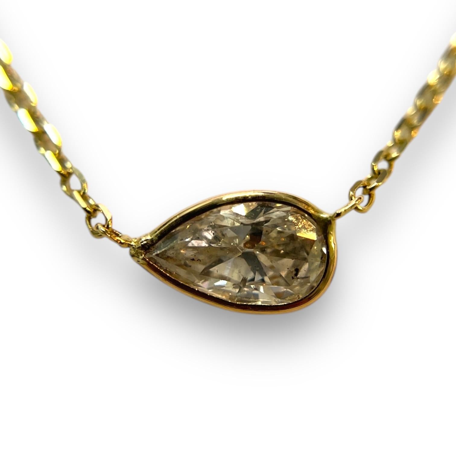 With its timeless elegance, this necklace showcases a 0.85ct natural pear-cut diamond in a smooth 14K yellow gold bezel. The adjustable chain ensures a perfect fit for any occasion, from casual outings to formal events.