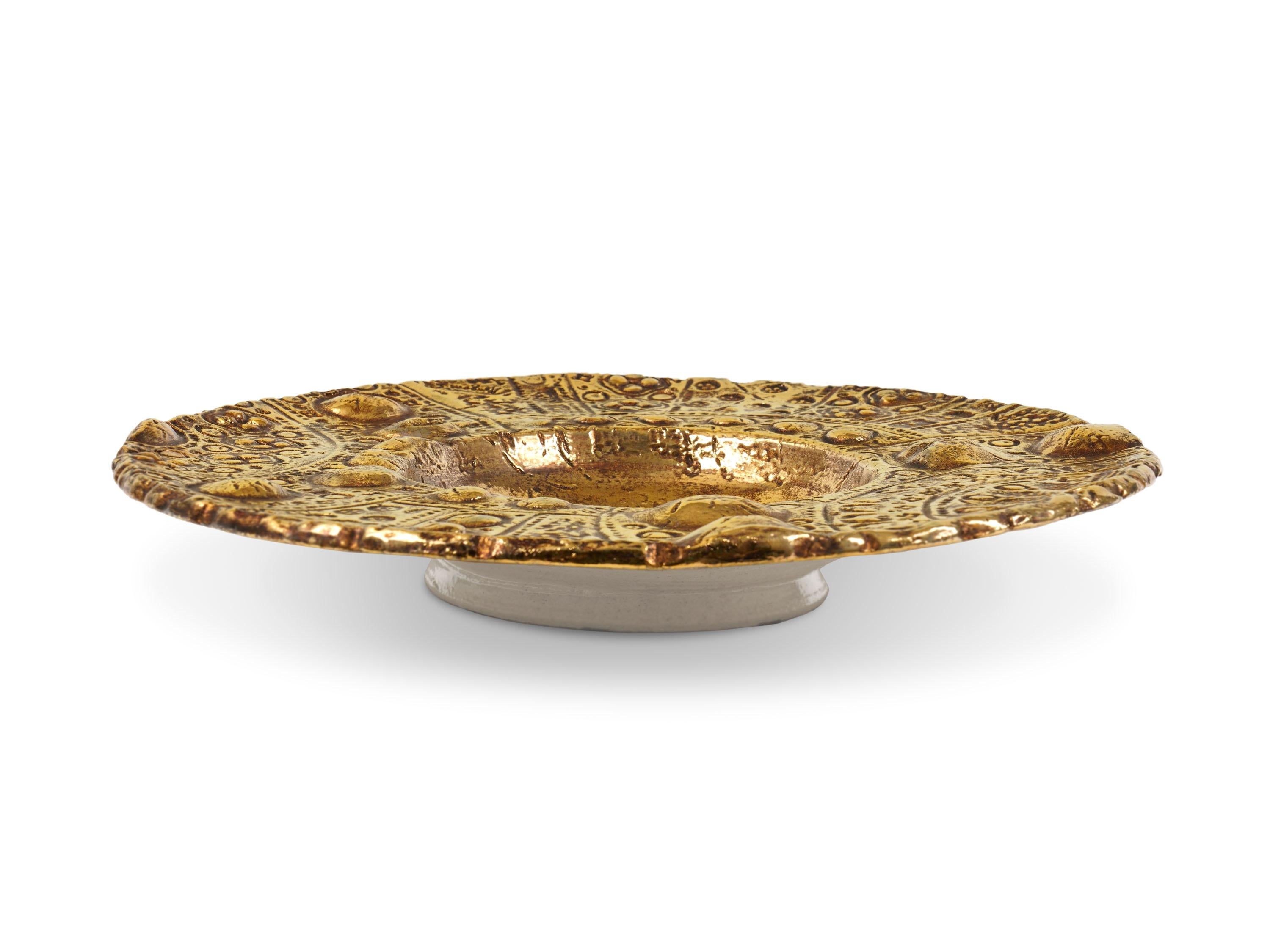 Majestic sculptural plate made of ceramic and decorated in 24 Karat gold with the luster technique. The plate can be used as a centerpiece or can be modified to be wall mounted upon request. This sculptural plate has a great aesthetic impact thanks