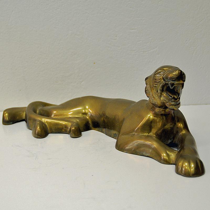 Beautiful and majestic mid-century tiger figurine in a relaxing lying position. Holed underneath. This vintage brass animal would look amazing displayed on a fireplace mantel or book shelf or just on the livingroomtable. Probably Scandinavian. Good