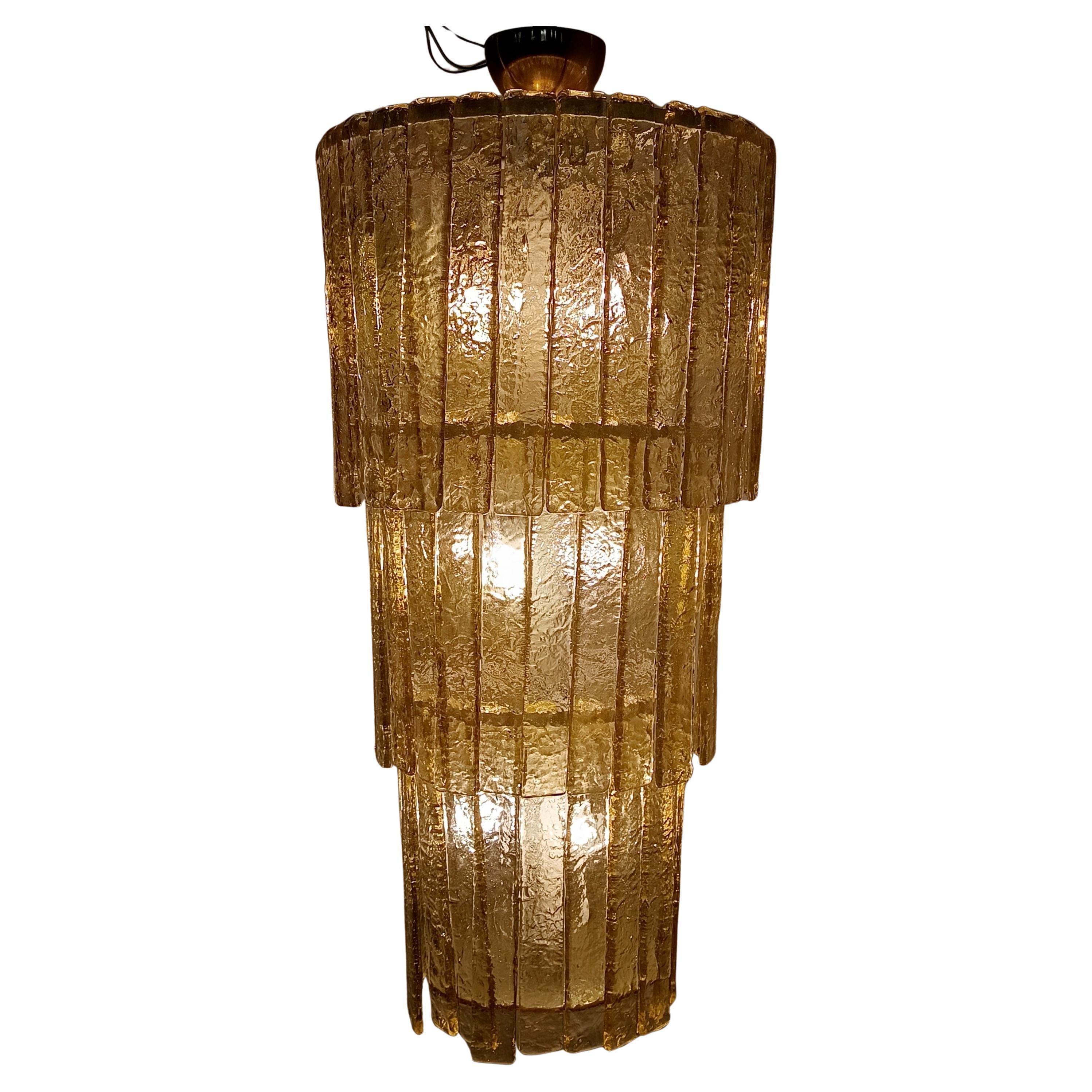 Hergestellt in Italien, 1970er - 1980er Jahre. 
Wunderschöner großer Kronleuchter, der in den 70er/80er Jahren in den Öfen von Murano vollständig handgefertigt wurde, aus gelbgoldenem Glas, bestehend aus 77 heiß geformten Platten.
Das
