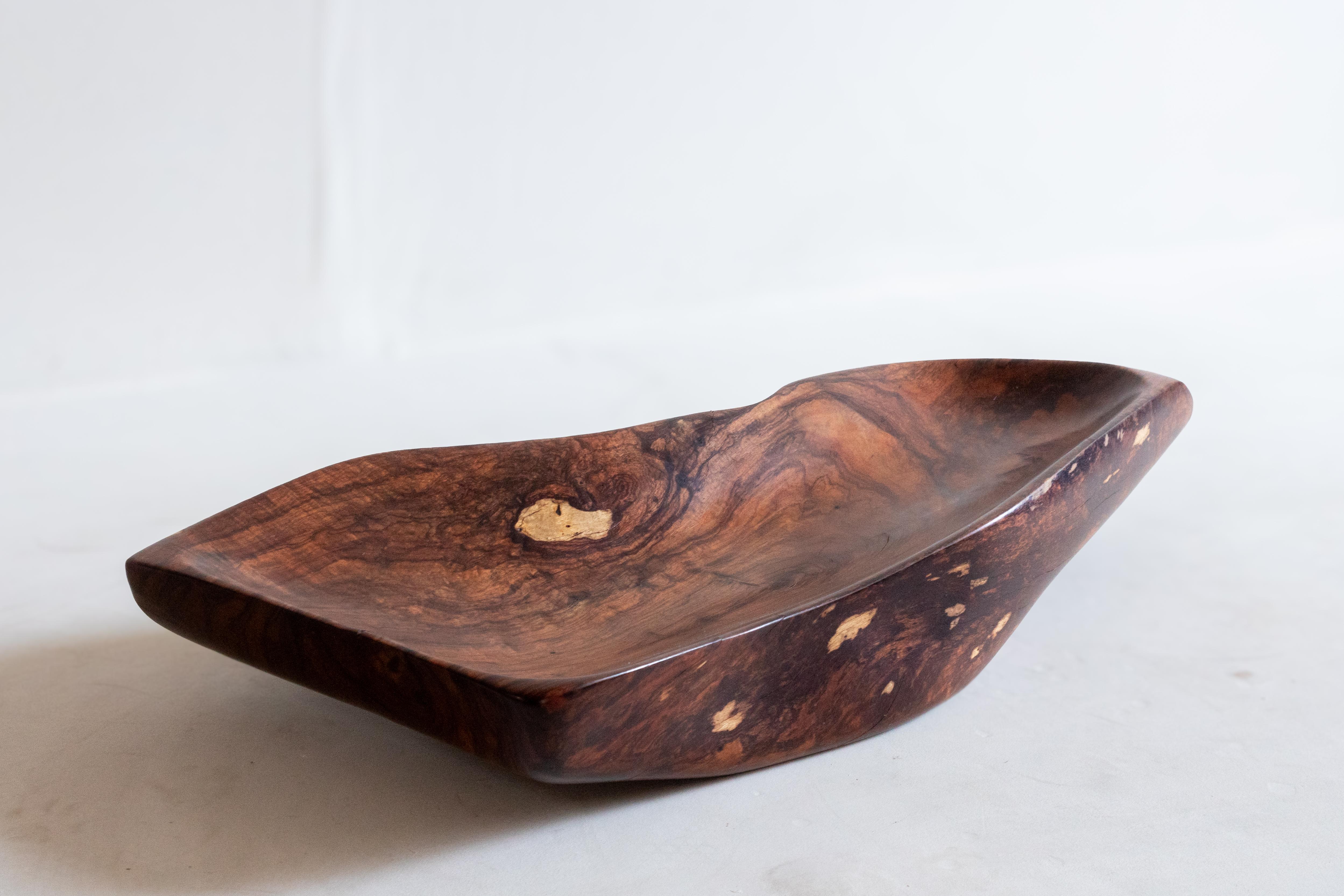 Questo magnifico centrotavola, intagliato a mano nel lussuoso legno di Granadillo, presenta lunghe curve sinuose che gli conferiscono un aspetto organico e naturale. Ricavato da legno recuperato nella Jungling Maya del Messico, questo pezzo unico è