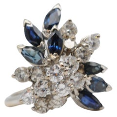 Majestuoso anillo en racimo con diamantes y zafiro en oro blanco de 18k