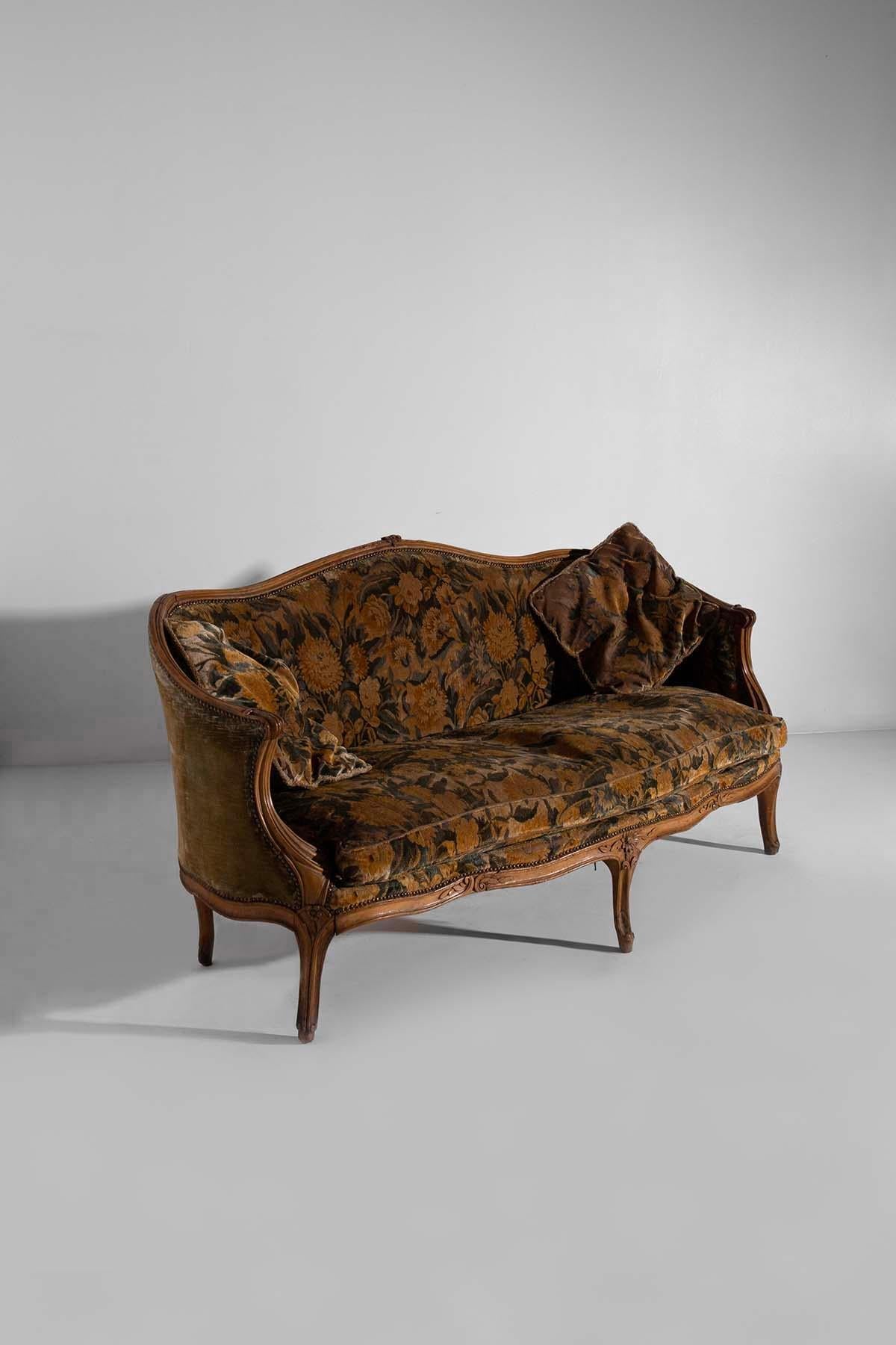 Entdecken Sie den Charme dieses Sofas aus dem frühen 20. Jahrhundert mit italienischem Floralstoff. Jedes Detail dieses Sofas, von den sorgfältig ausgeführten Holzschnitzereien bis hin zum Vintage-Stoff, spiegelt italienische Kunst und