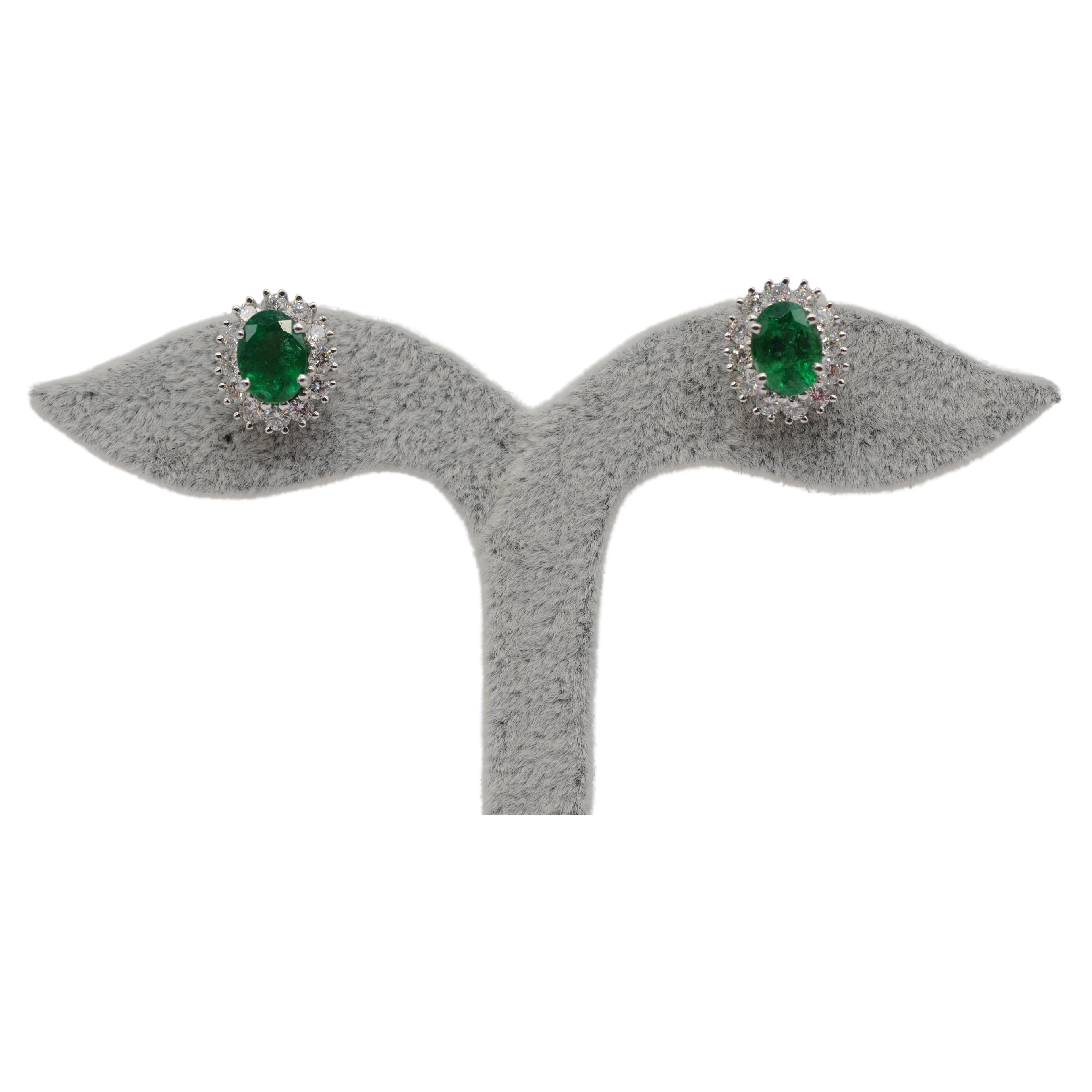 Indulge in the breathtaking beauty of this pair of exquisite earrings, meticulously crafted with emeralds and diamonds set in 18k white gold. Each ear stud boasts twelve diamonds, each weighing approximately 0.05 carats, expertly cut in brilliant