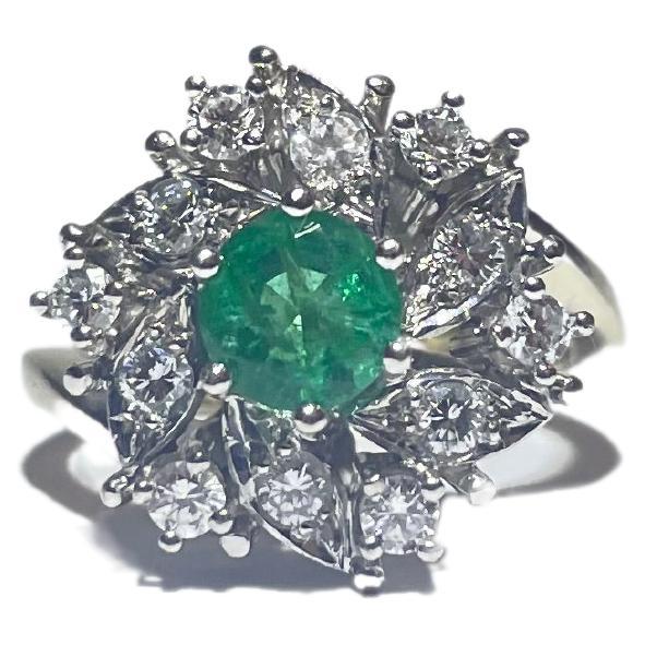 Behold the breathtaking beauty of this exquisite 14k white gold ring, a true masterpiece that exudes elegance and regality. At its heart rests a magnificent emerald, resplendent in its emerald-cut brilliance, boasting a size of 0.60 carats. This