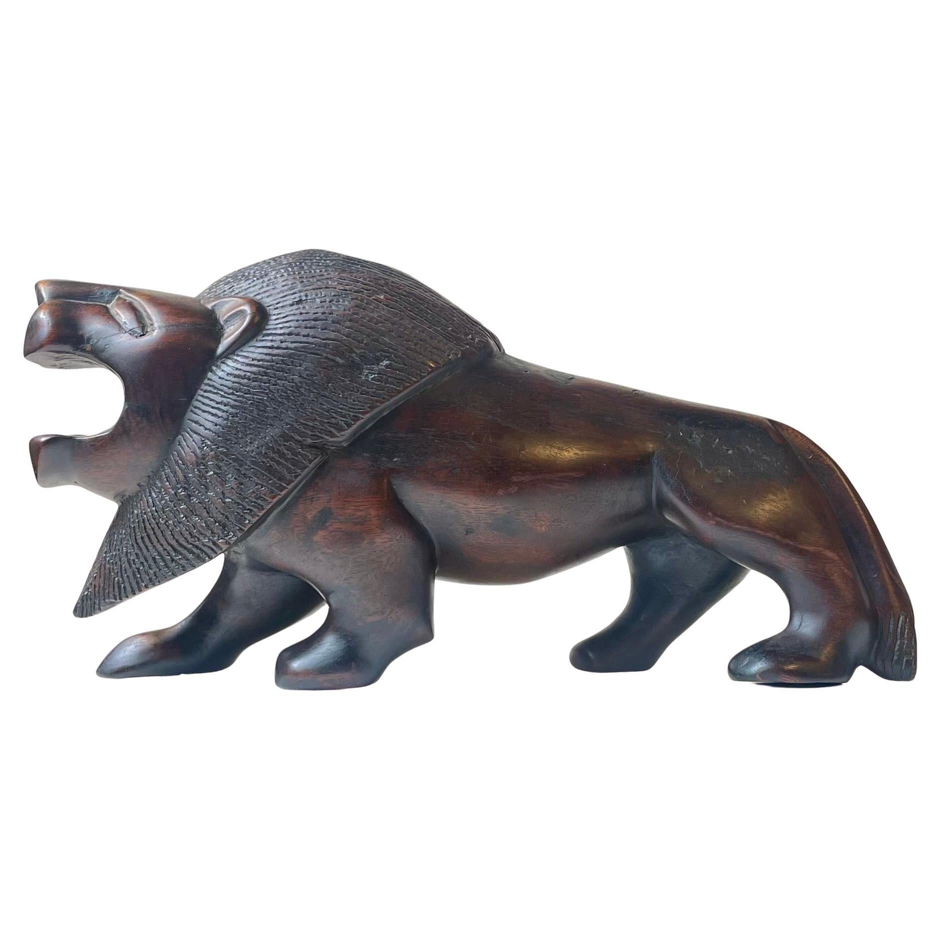 Majestueuse sculpture de lion en bois dur foncé sculpté