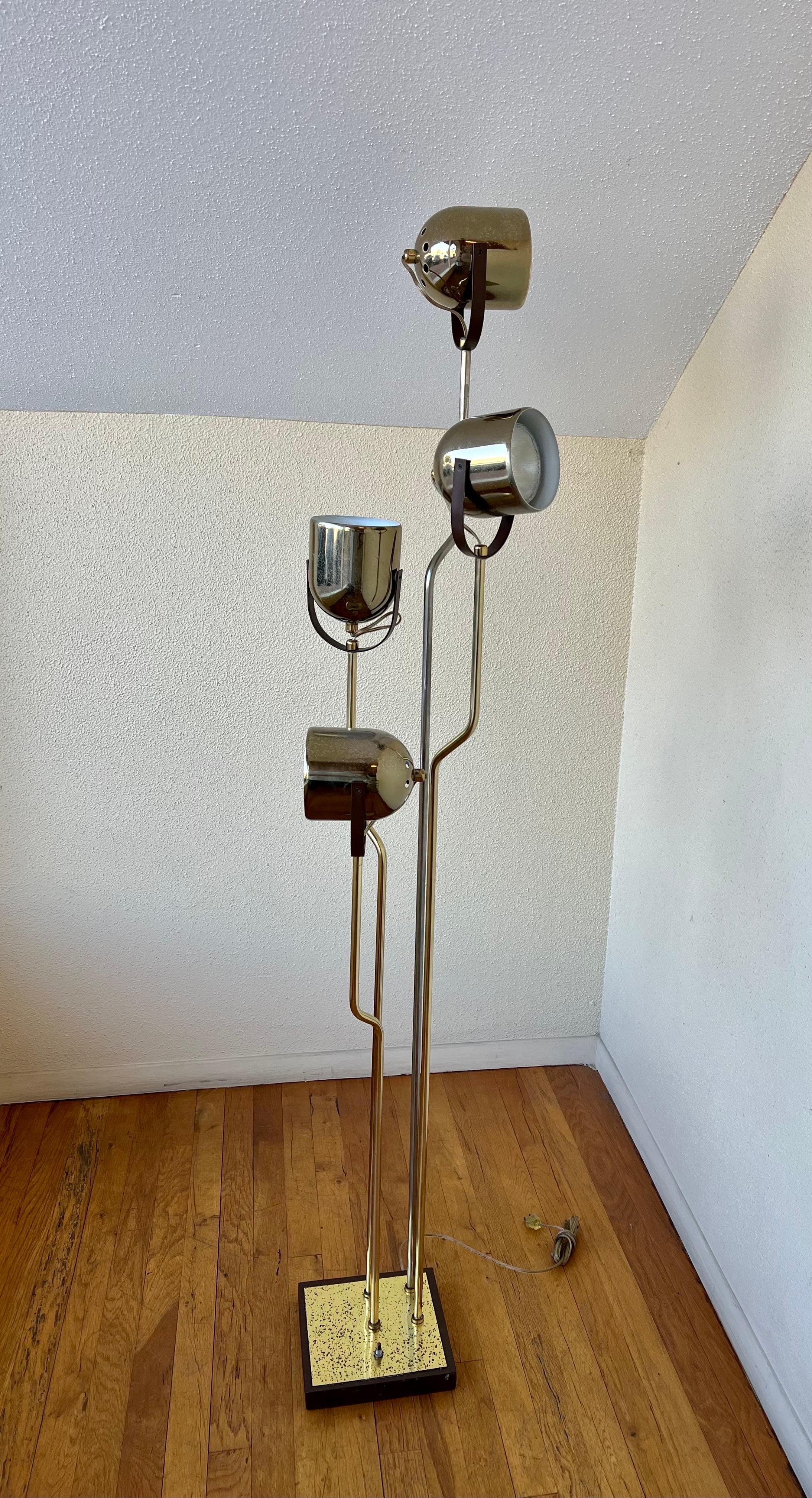 Floor lamp designed by Goffredo Reggiani with four adjustable round heads. Can be lit by four or two lamps at a time with a floor light switch. Cast iron base. The lamp shows a natural patina and brass can be polished its majestic and