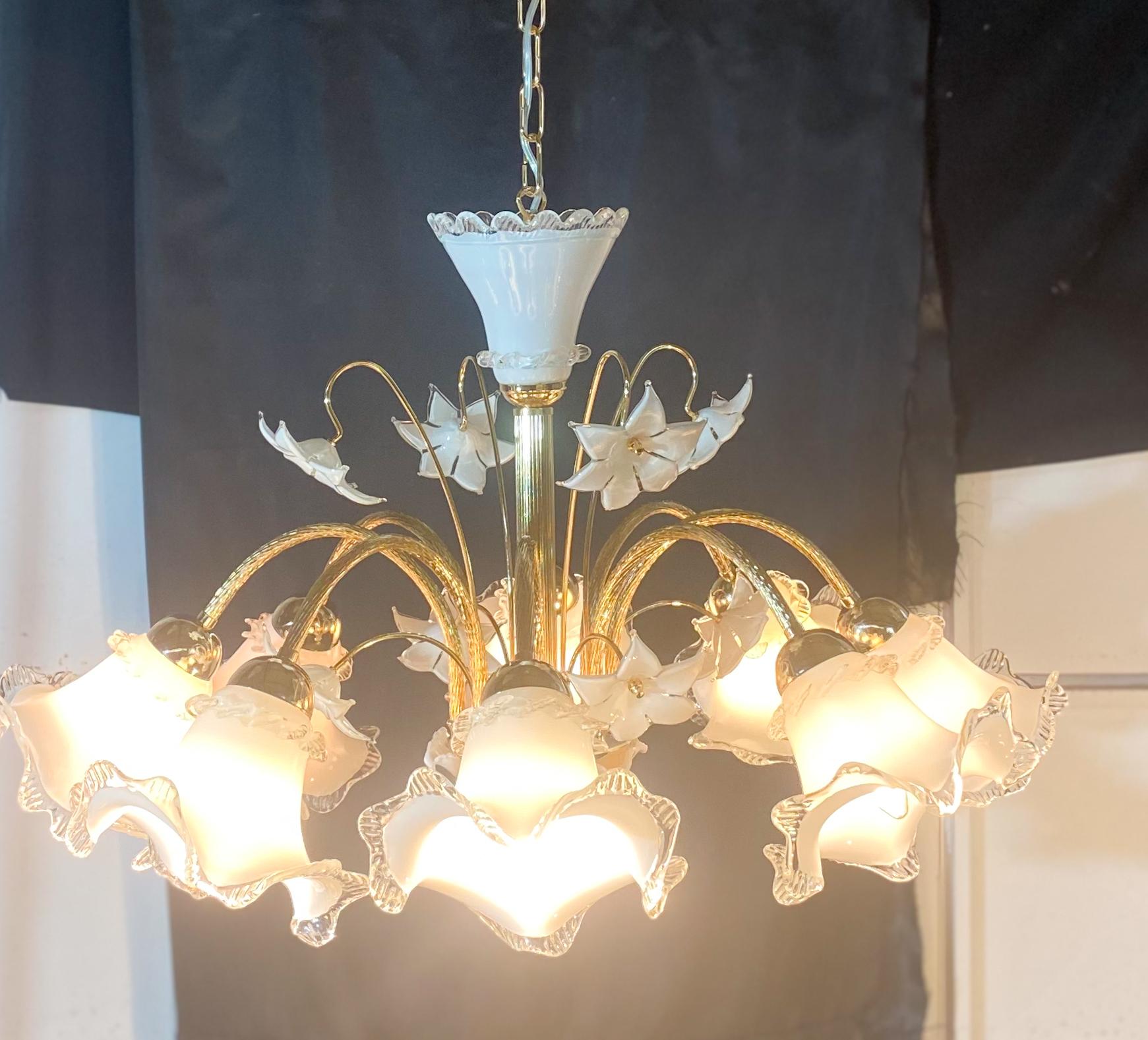 Majestic Murano chandelier with 8 arm lights. Example of Venetian blown glass technique.The chandelier consists of 8 cups and decorative flowers.The structure has been perfectly restored with the golden bath technique, the electrical system has also