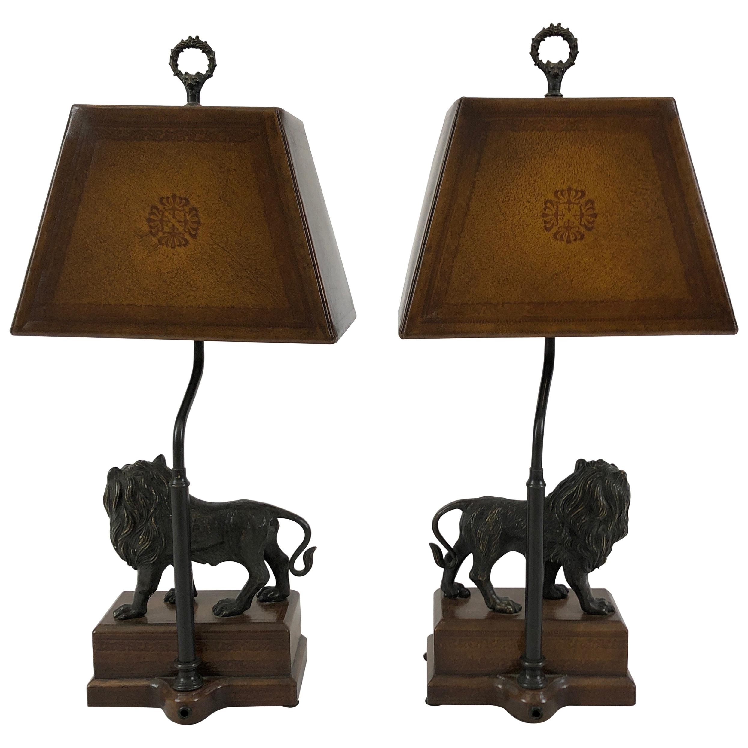Two masculine table lamps by Theodore Alexander having sculptural bronze lions on wooden bases and rich leather lampshades with the Classic designer stamp. A gorgeous finial finishes each lamp at the top.