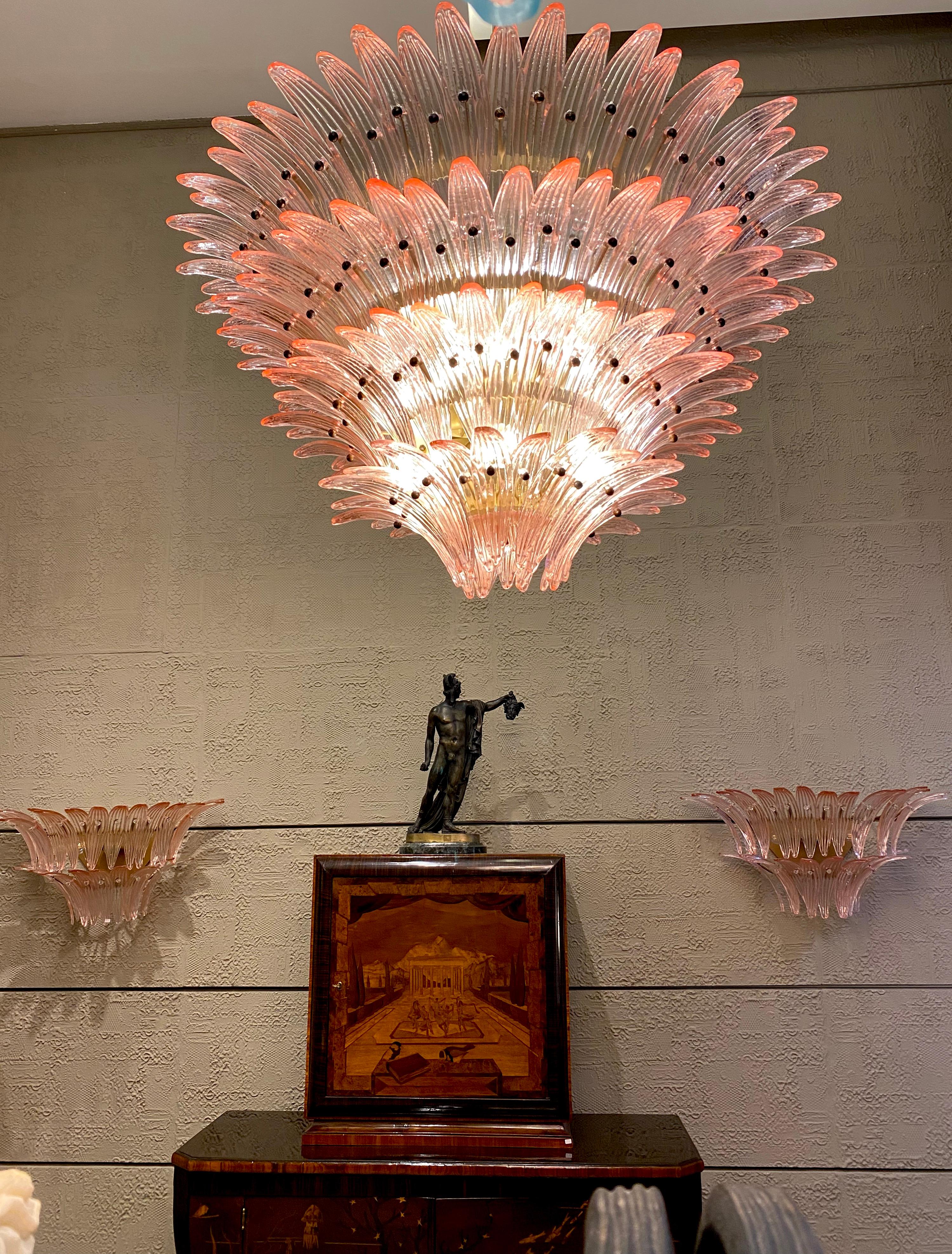 Outstanding pink Palmette Murano glass chandelier made with 163 precious glasses on four levels.
Gold painted metal frame.
Available also a pair and a pair of sconces.
12-light bulbs, E27 dimension
Dimensions: 55.10 inches (140cm) height with chain,