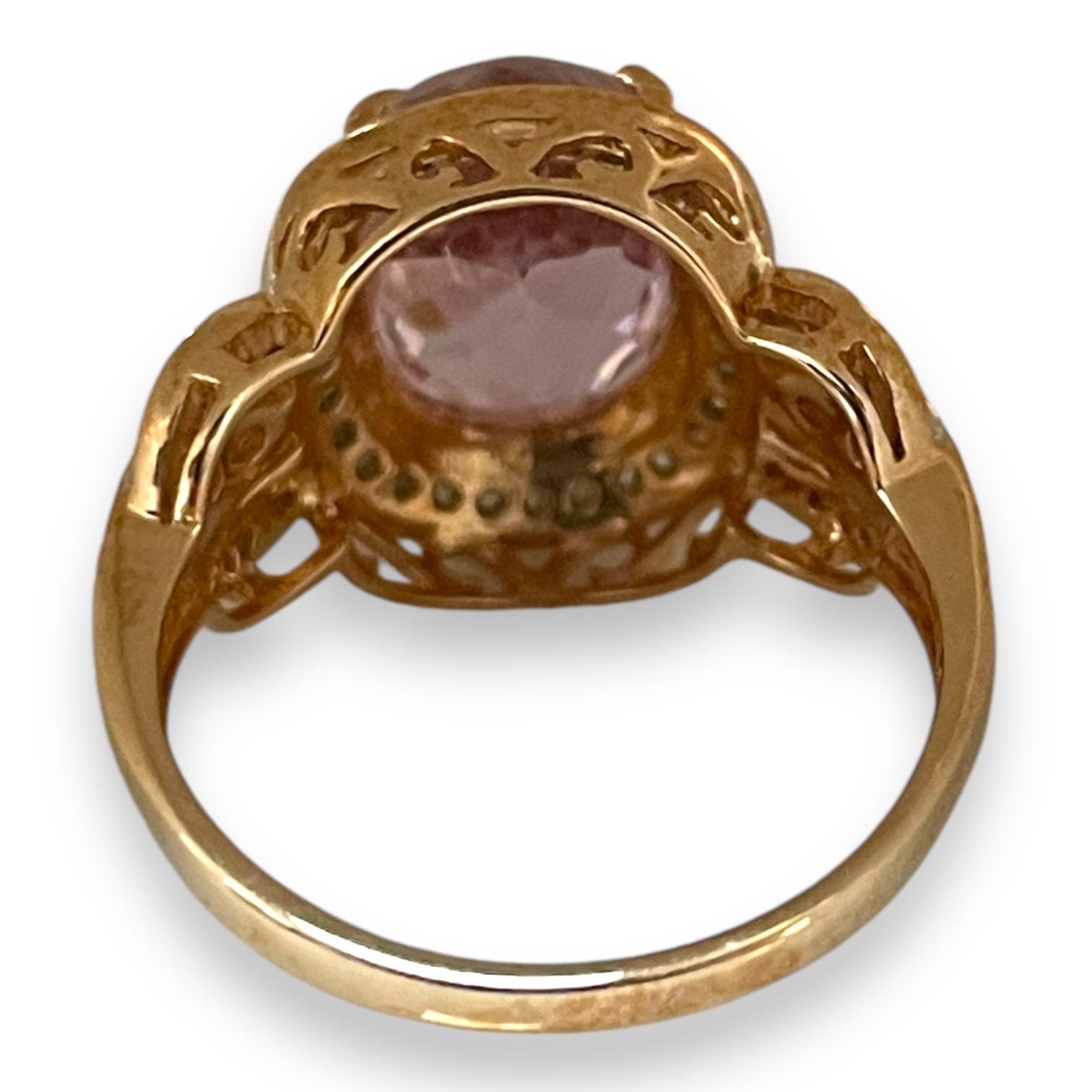 An enchanting pink sapphire takes center stage in this captivating ring, adorned with a halo of shimmering diamonds that add brilliance and charm. Set in 10k yellow gold, the sophisticated band is detailed with smaller pink sapphires nestled within