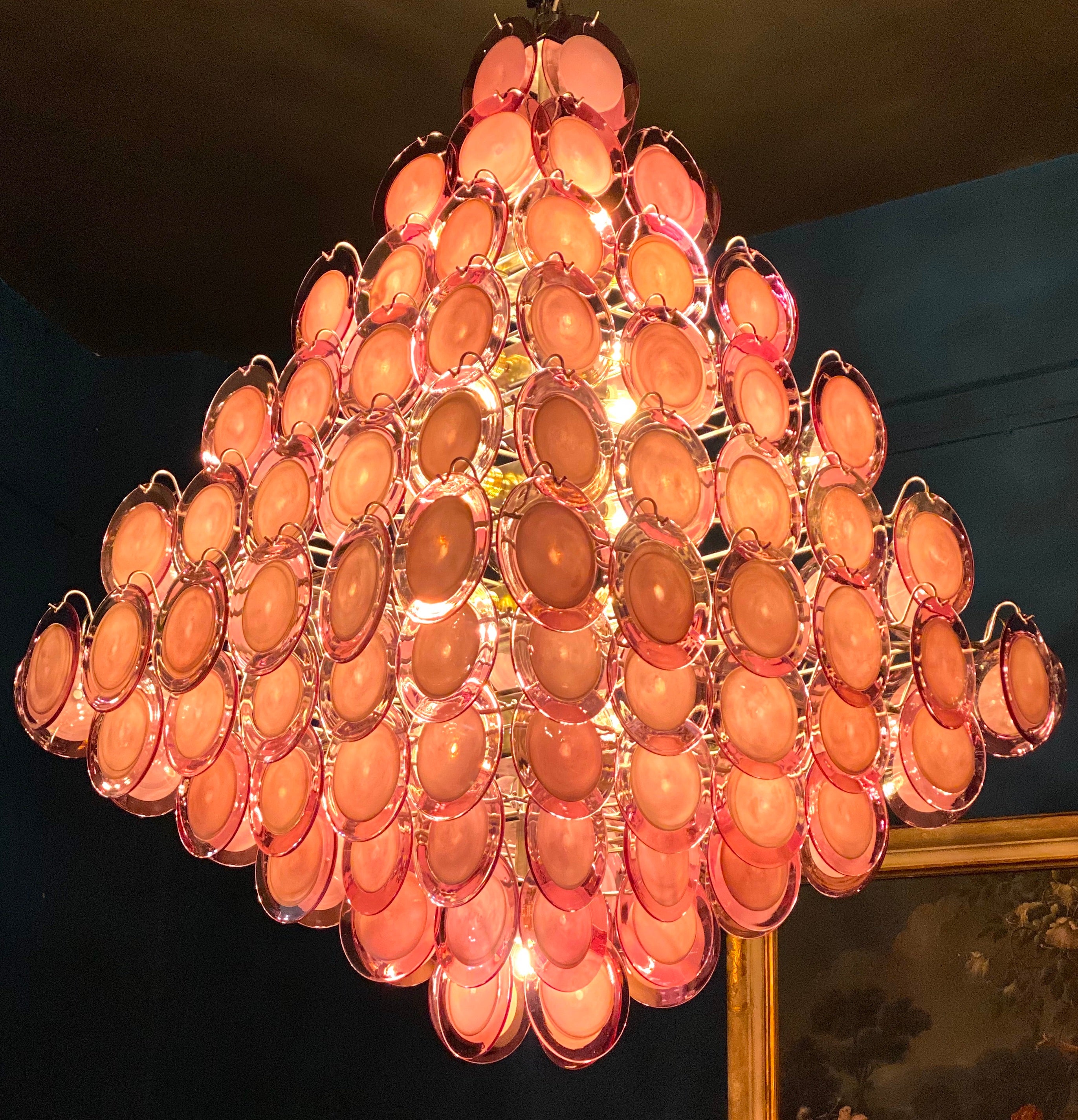 A chandelier of rare beauty and elegance. 136  Purple Murano glass discs disposed in ten rows, forming two overlapping pyramids. 
 21 E 27 light bulbs up to 40 watts per bulb.
A pair is available. 
This light fixture can be disassembled and the