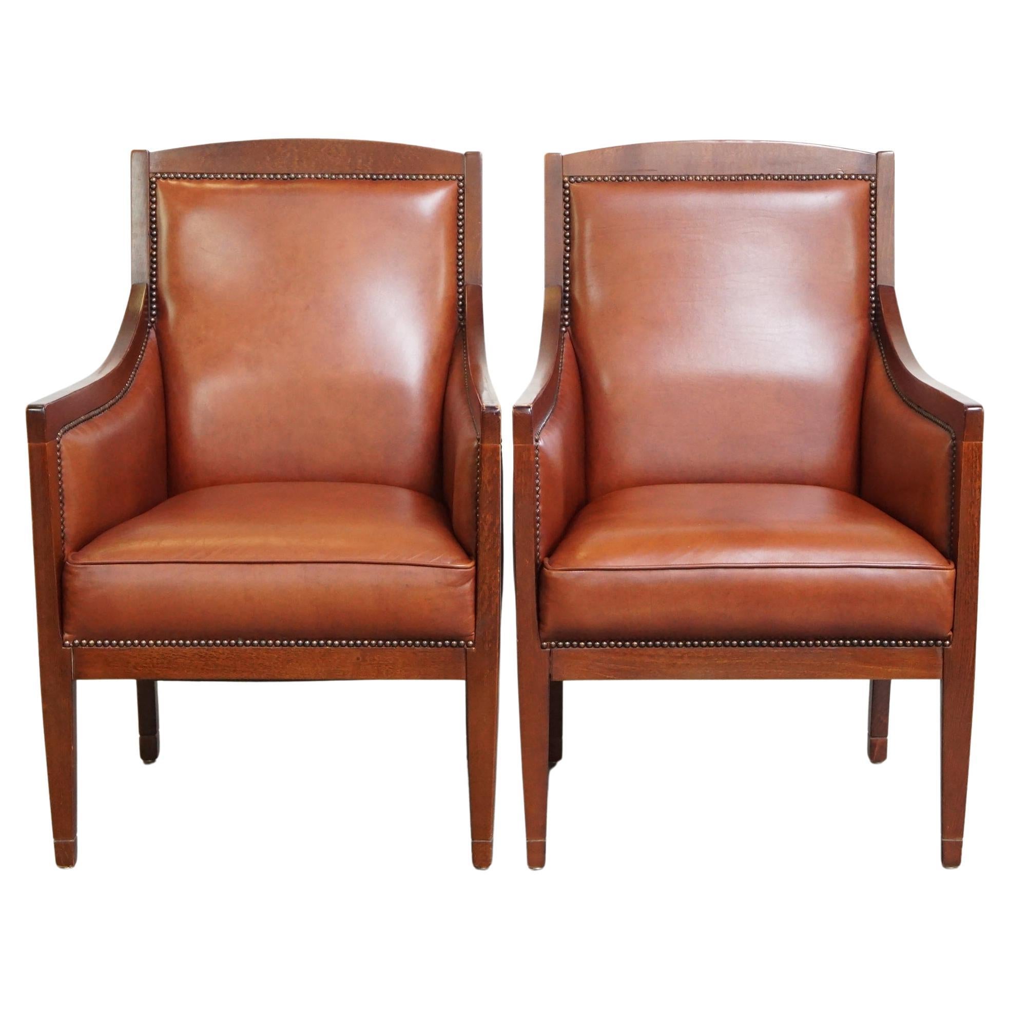 Majestueux ensemble de 2 fauteuils Art Déco en cuir de vache de couleur cognac