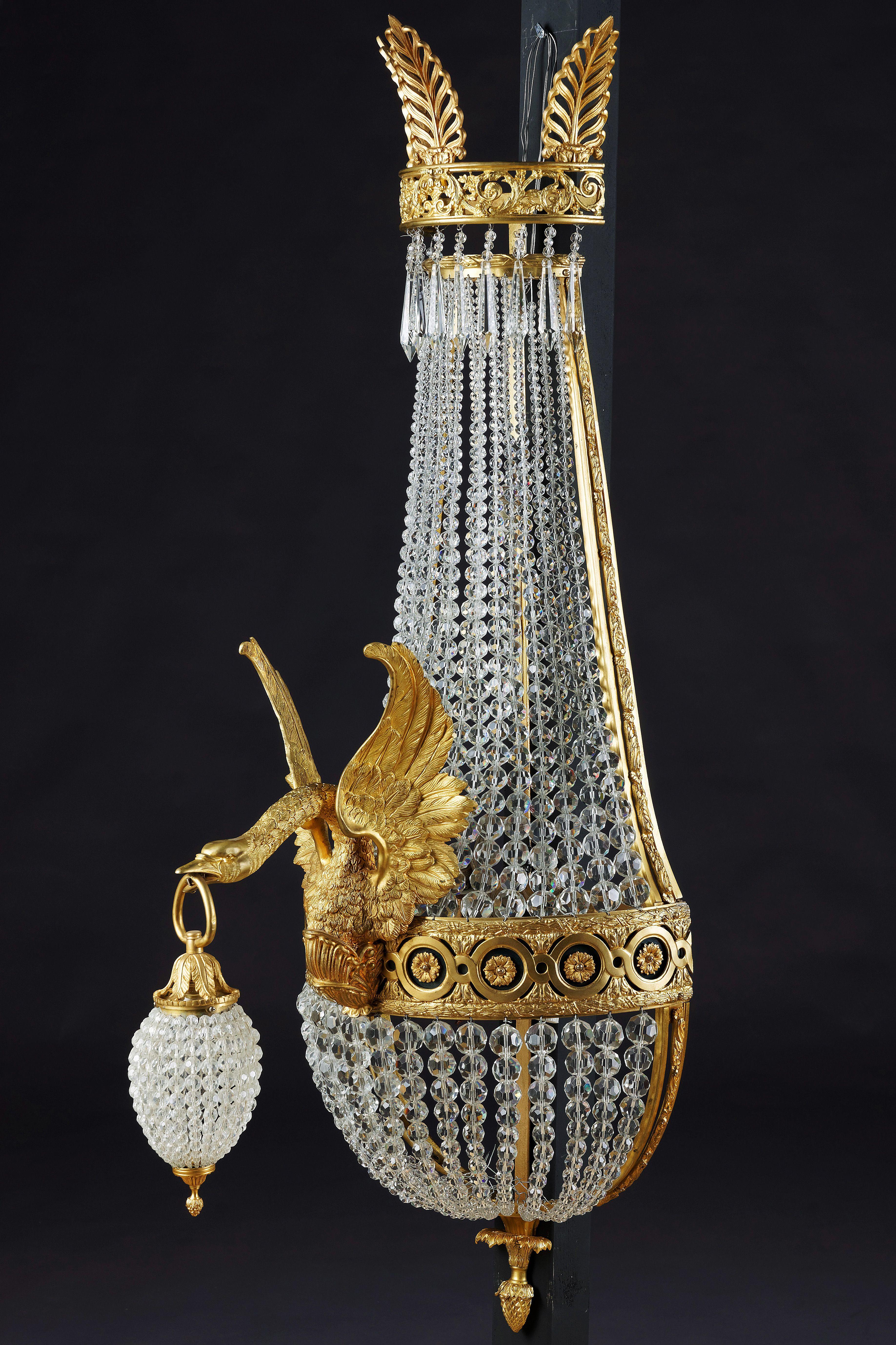 Majestic basket wall light in Empire style.
Exceptionally fine engraved and cast bronze. Basket-formed corpus,connected through wide, ornamental reliefed and broken hoop. There from, one fully moulded swan-designed light arms. Electrified. In beak,