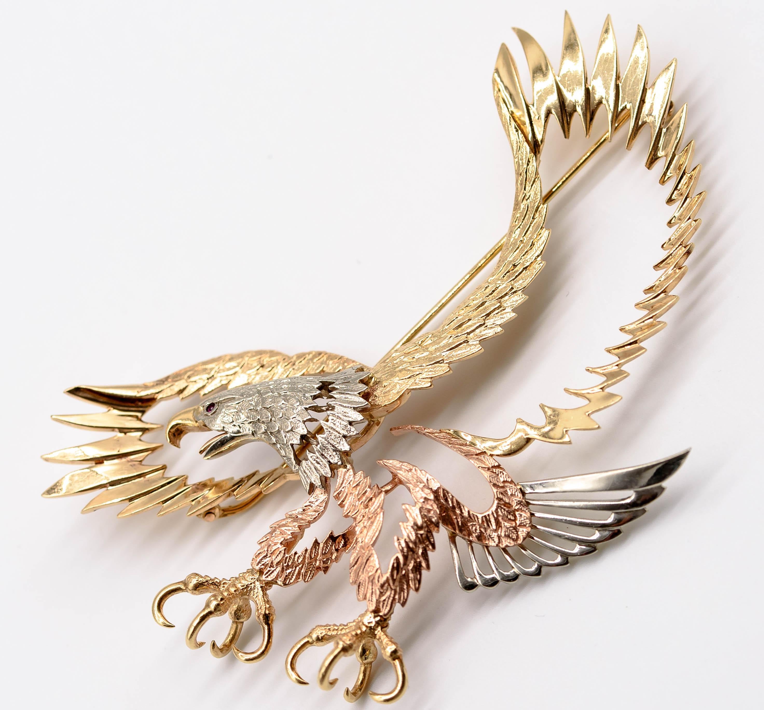 An expansive and elegant brooch depicting an eagle arching towards its prey with talons outstretched - and the brooch's owner gets to choose the nature of the prey.  Beautifully crafted in 14 karat yellow, rose, and white gold, the brooch spans 4