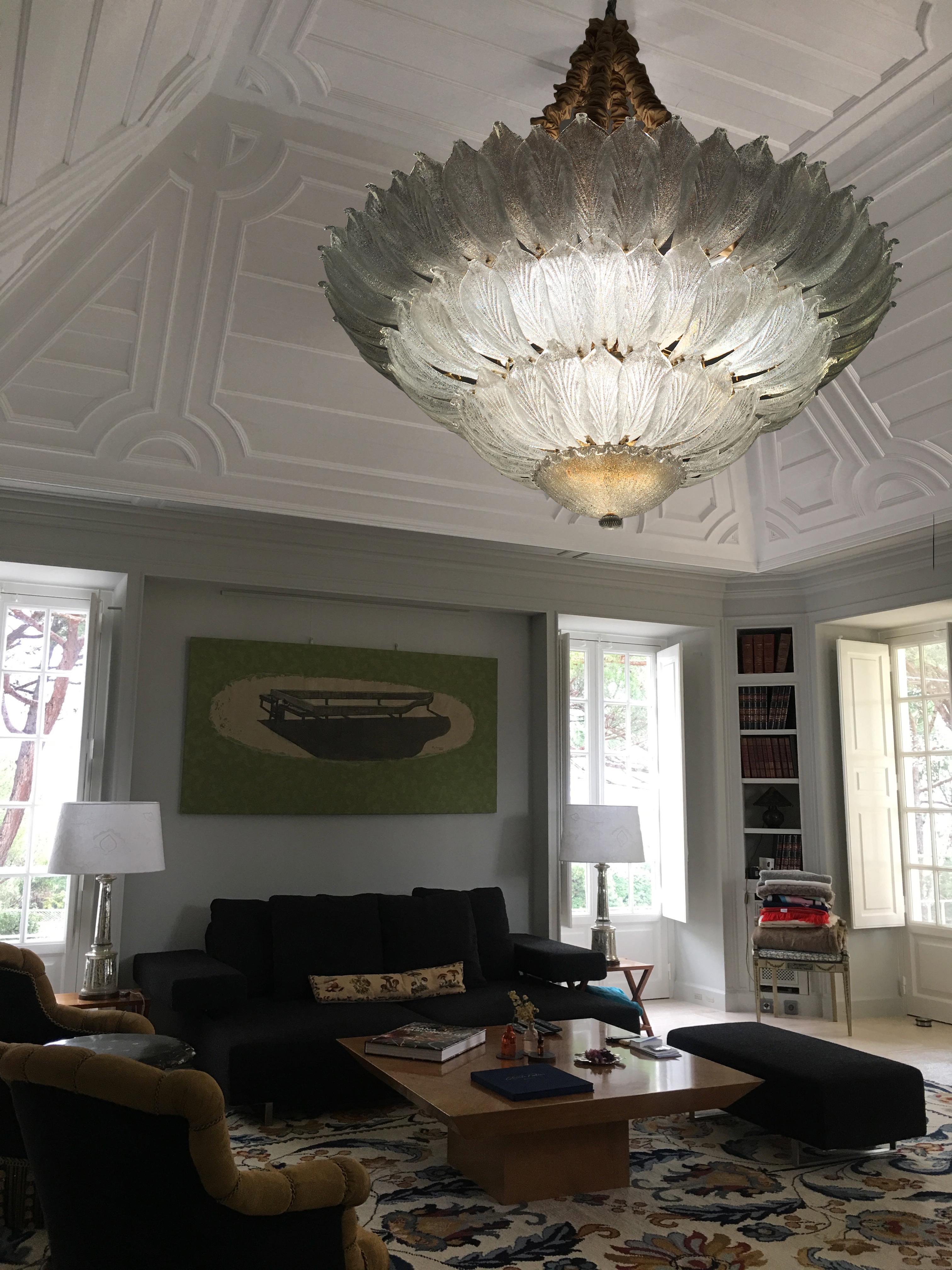 Majestic Venetian ceiling light realized in pure Murano glass consists of an incredible number of leaves. The structure is plated with gold. 18 lights spread a magical light. Measures: Diameter 156 cm, height 58 cm and chain. Also available ceiling