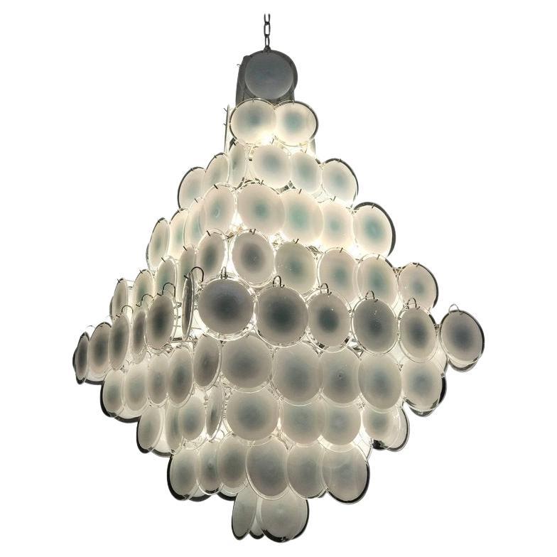 A chandelier of rare beauty and elegance. 134 Murano white
'lattimo' glass discs, disposed in ten rows, forming two overlapping pyramids.
 A pair is available and also with pink disc. 
We can rewire for Us standards.