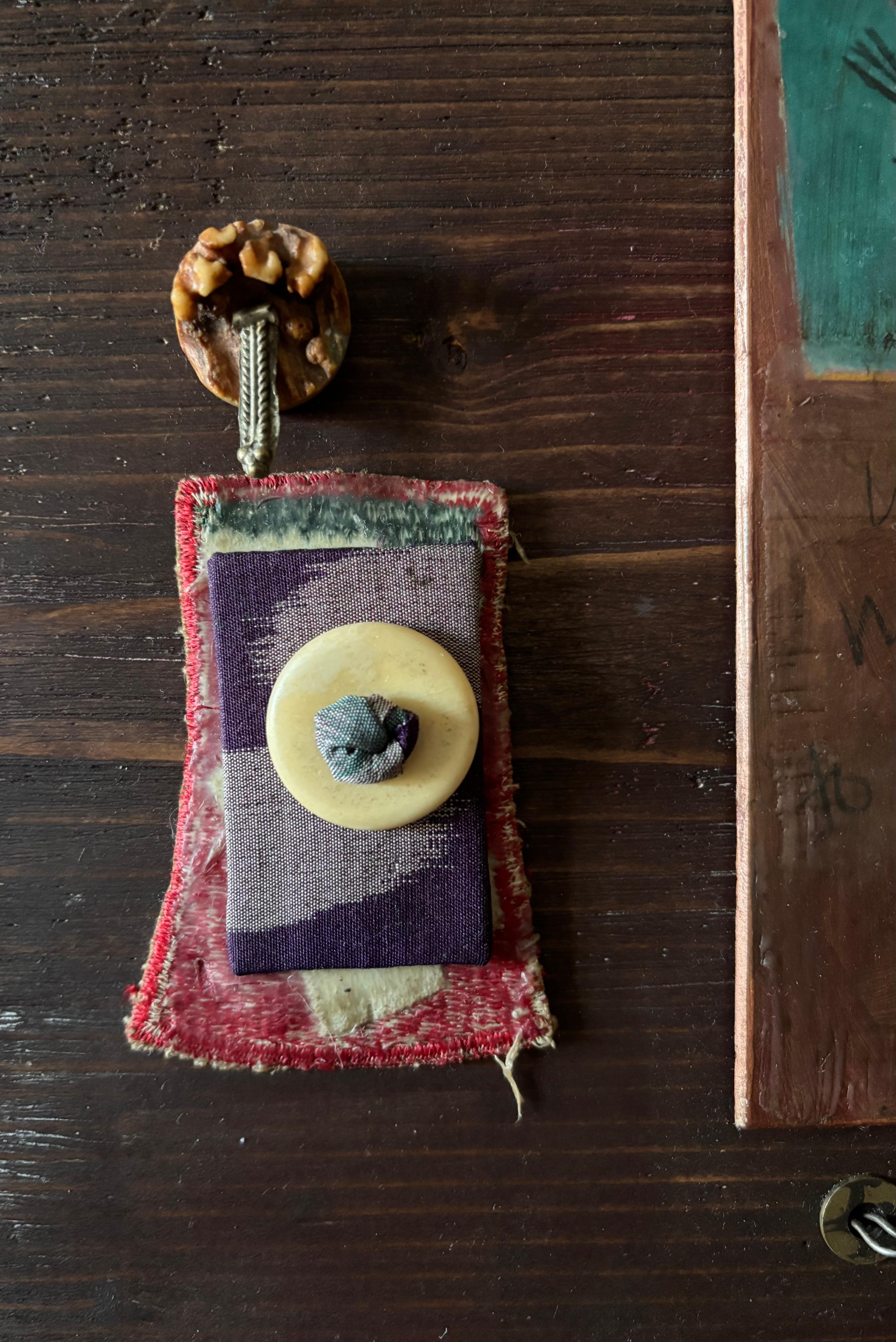Crows, Red/black Japanese hanafuda gambling card, fertility and silver charms. The worn spot beneath the curved wire asks what’s missing?

The format of our stories are reluctant to change and yet may be and are often changed by the smallest thing.