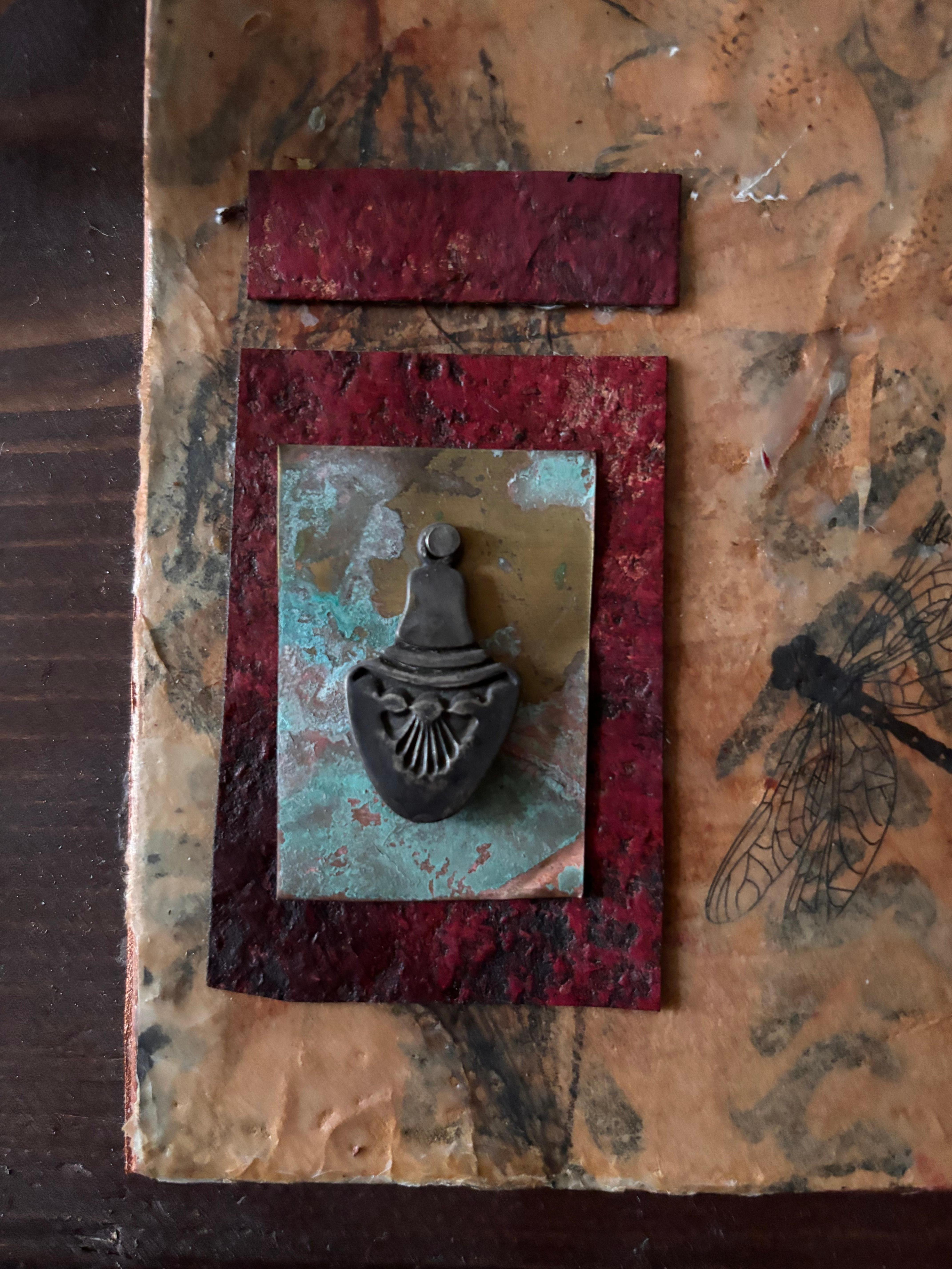 El dorje tibetano, objeto ritual del budismo tibetano, simboliza la indestructibilidad y la irresistibilidad, mientras que domina un cuervo que asoma por detrás de la escritura japonesa de hah. 

Artefactos de Realidades Varias Serie de cinco piezas