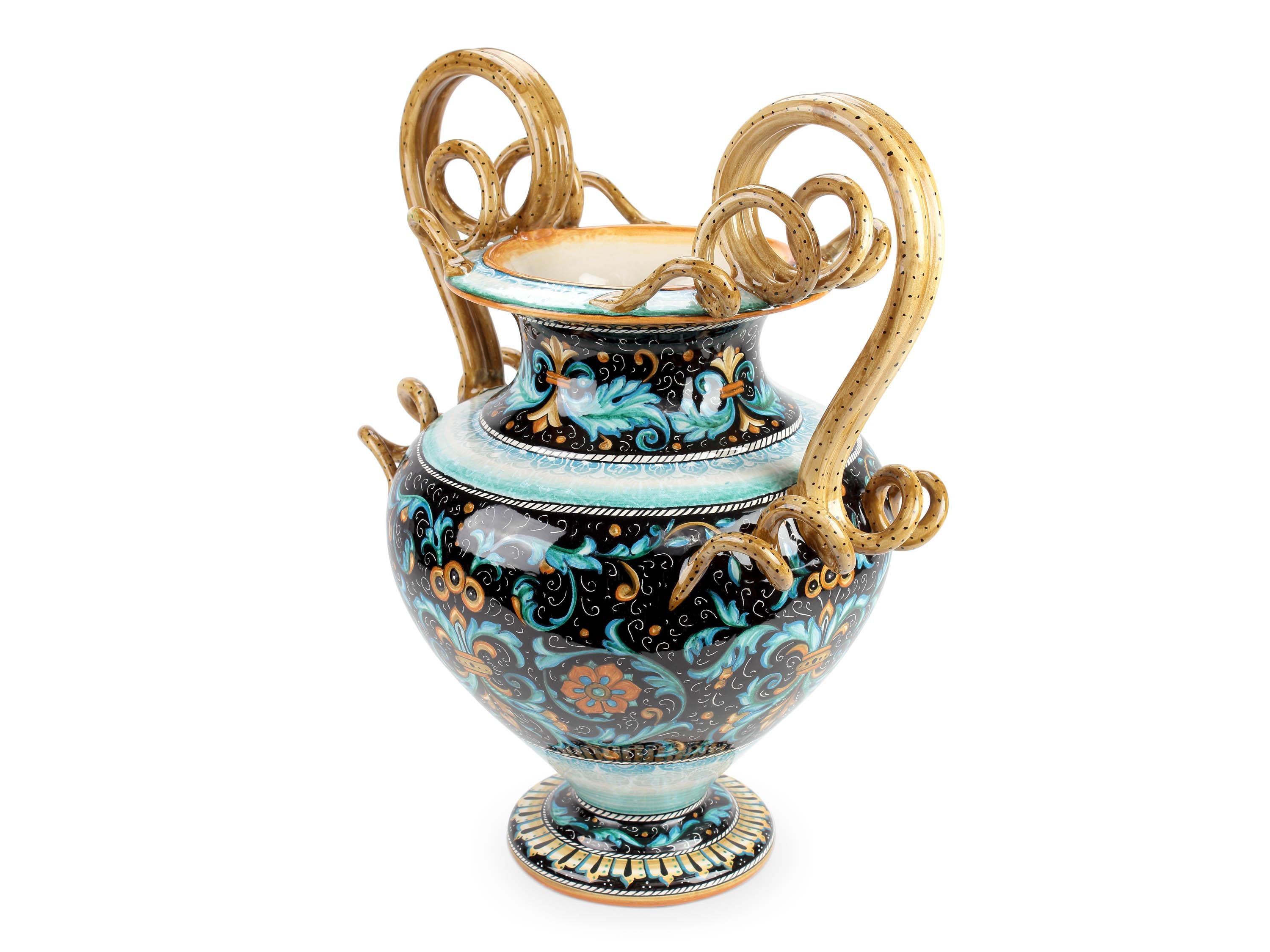 Amphora in majolica handmade in Italy and hand-painted in polychrome, decorated with a reinterpretation of the patterns used in Deruta during the Fifteenth Century, following the original Renaissance painting technique. The characteristic themes of