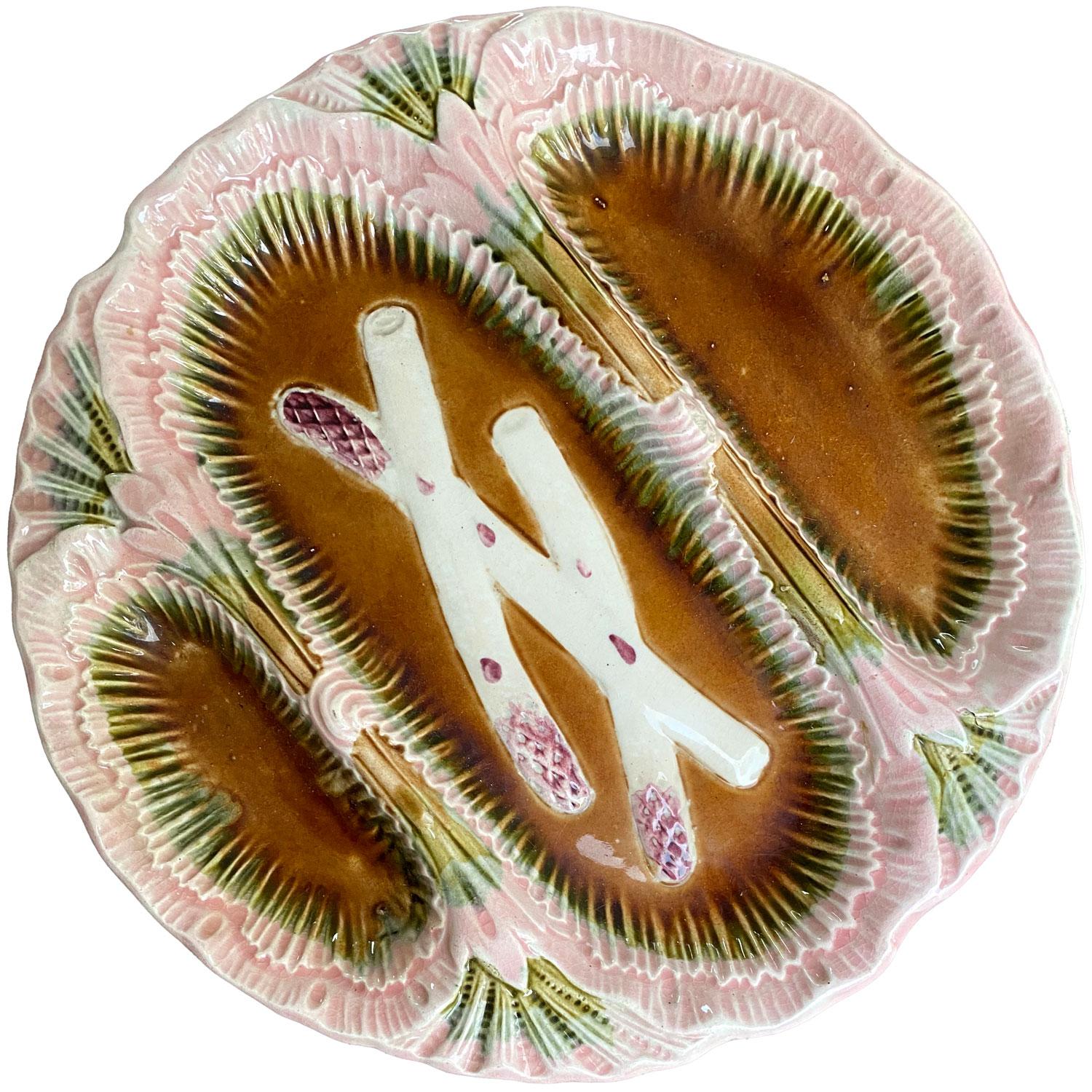 This 19th century Majolica asparagus hand-painted plate was made in France. Asparagus plate in pink and brown with three distinct compartments and decorated in the Louis XV style. Marked 23 on the Back. Work of the faïencerie d'Orchies.

The