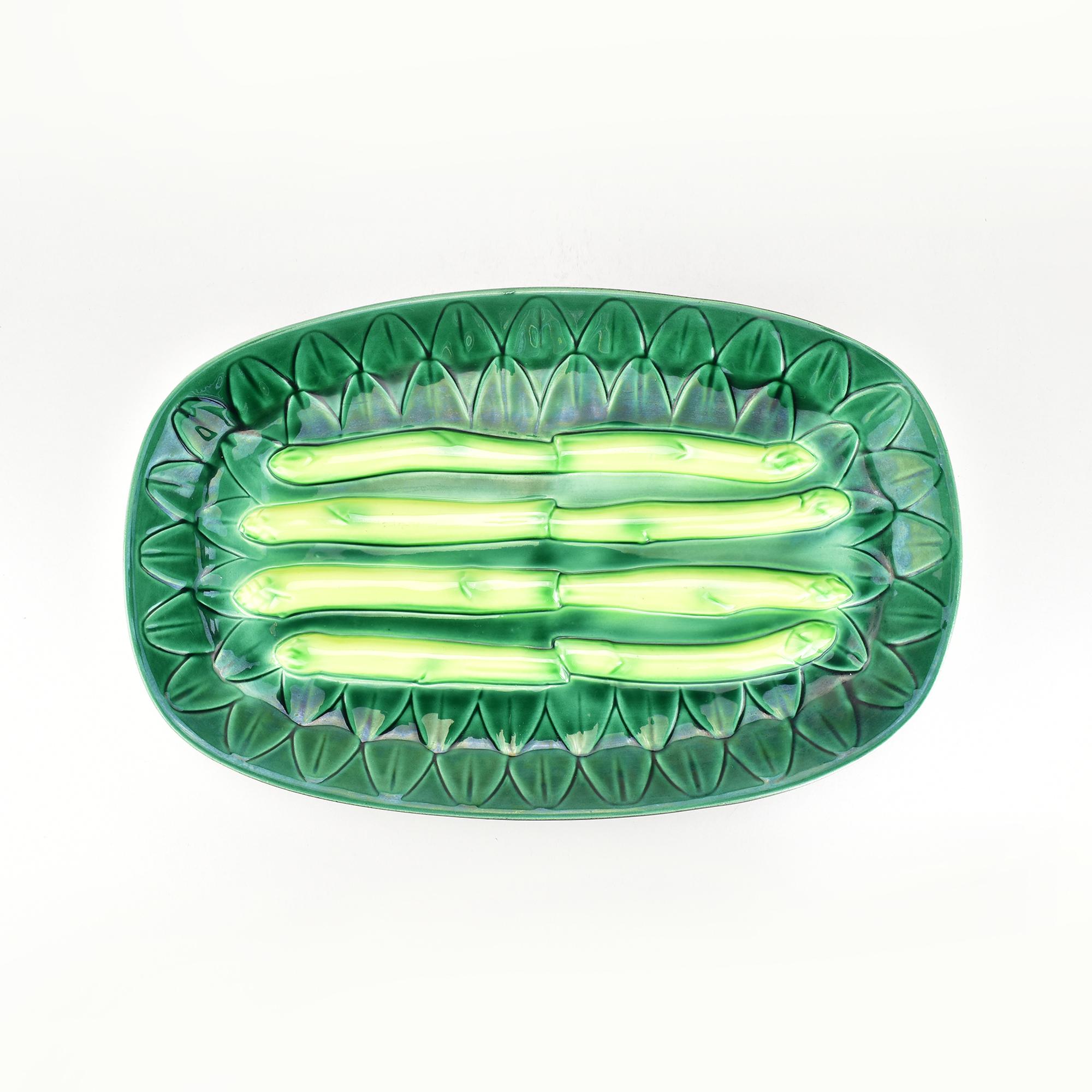 Un charmant service à asperges en majolique française par Elchinger, présentant une riche glaçure verte avec des motifs d'asperges en relief. Ce set en céramique Barbotine comprend un grand plat de service et six assiettes assorties. Les reliefs