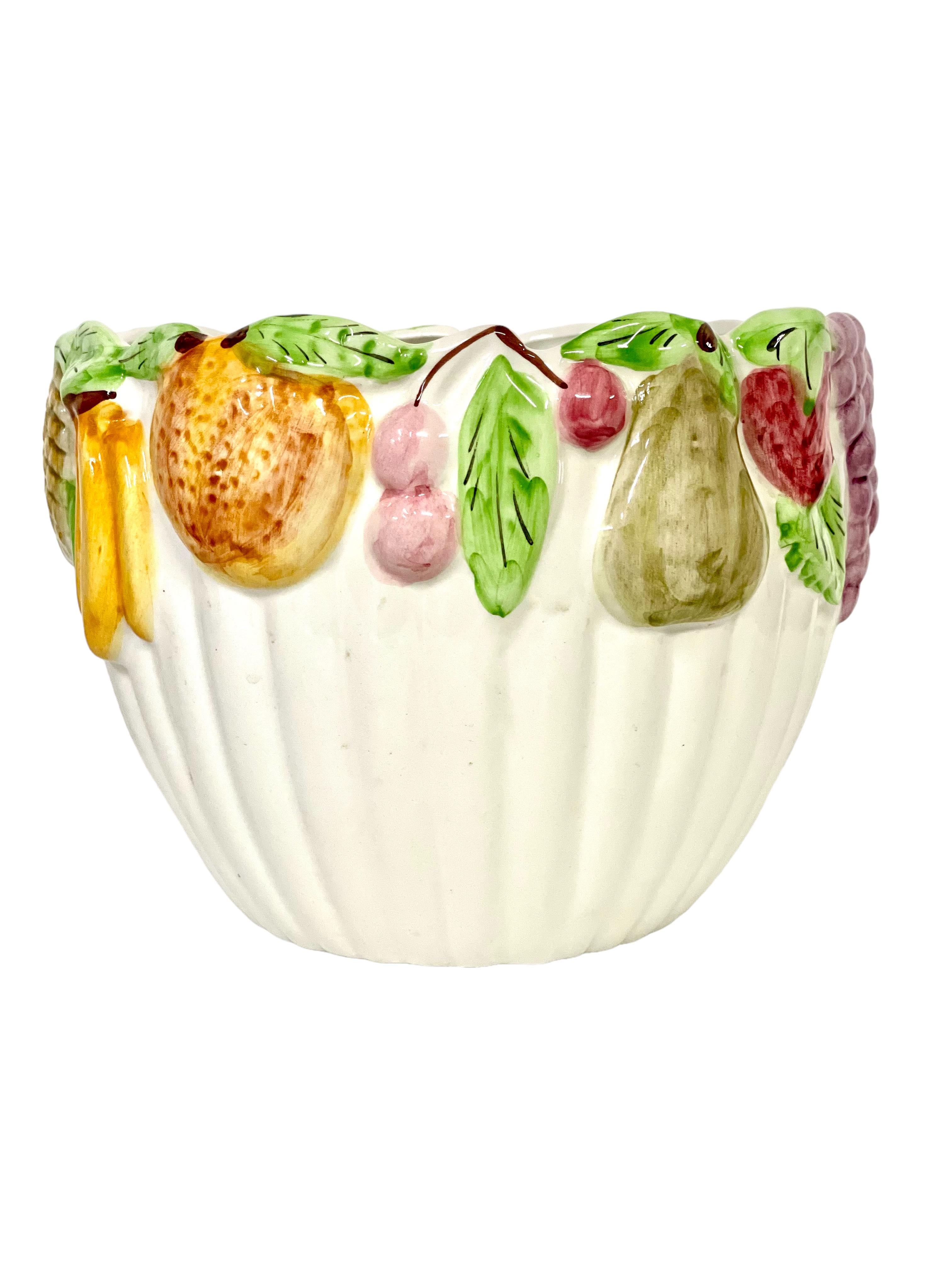 A quirky and very retro French Barbotine Majolica cache pot dating from the 19th century, and featuring an eye-catching design of succulent painted fruits encircling its rim. The pot itself is glazed creamy white inside and out, its curvaceous body