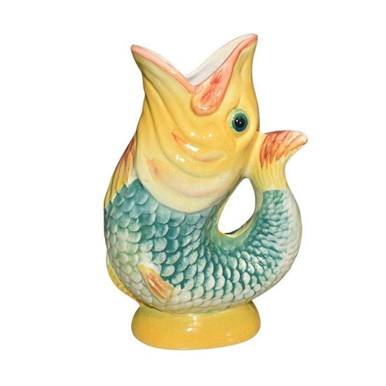 A ceramic chinoiserie Majolica gurgle fish pitcher. A great serving piece for a lunch table, or side table, this bright colorful pitcher will bring a pop of color to a place setting. The body of the fish features verdigris green scales. Its head and