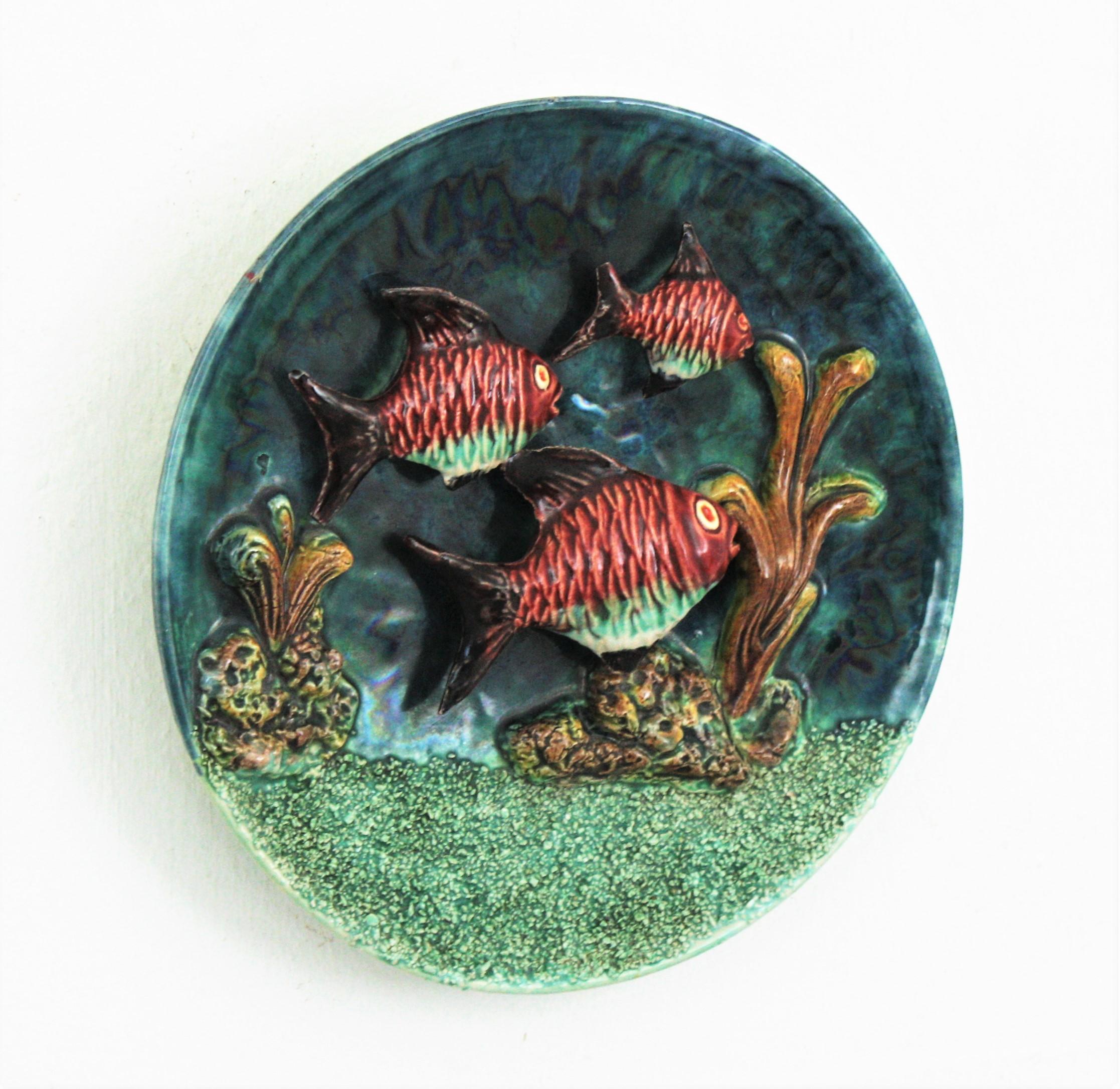 Eye-catching hand painted Majolica glazed ceramic deep sea landscape trompe l'oeil wall plate, Portugal, 1960s.
Such a realistic and colorful representation with fishes on a sea landscape background.
This wall plate will add a cool midcentury
