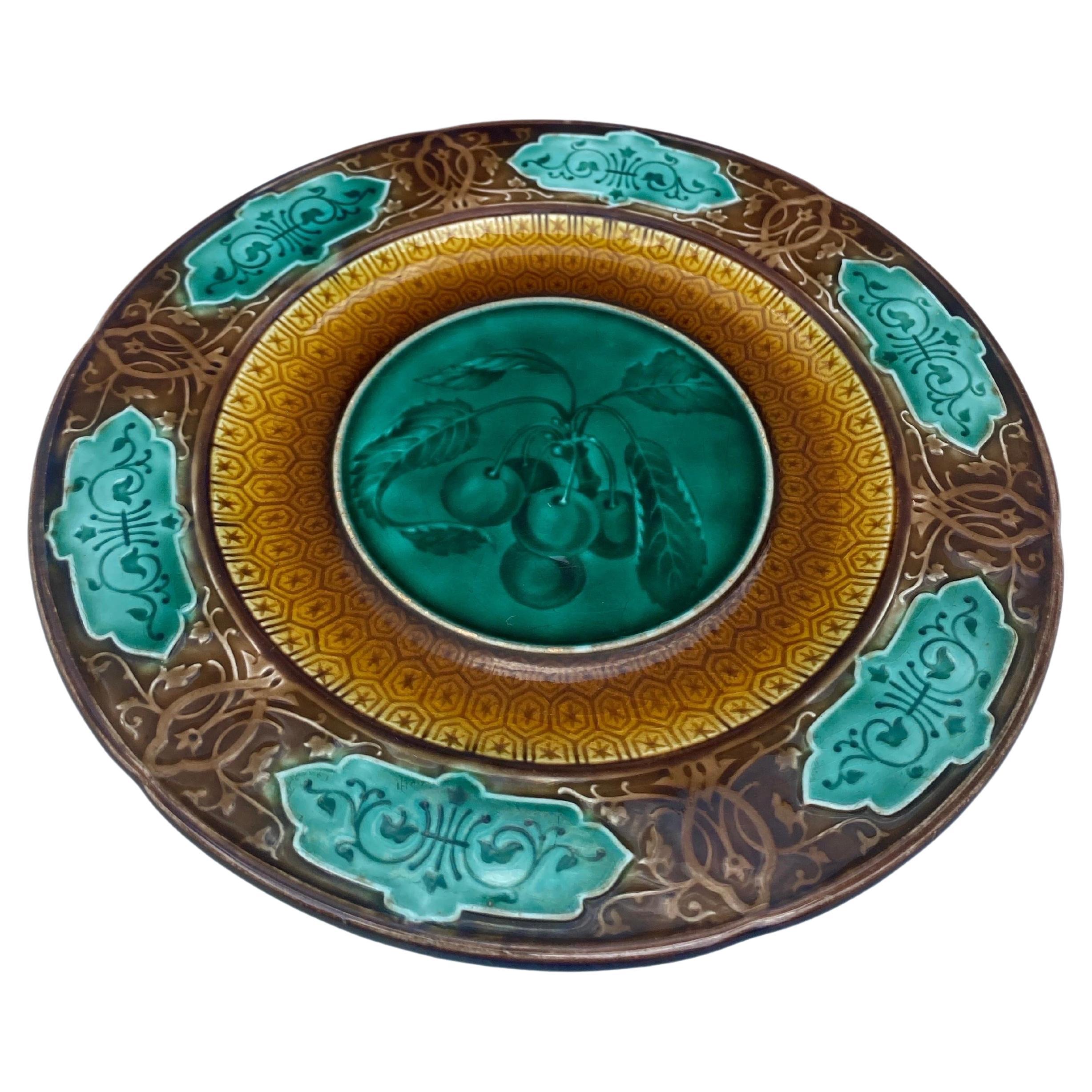 Plato de mayólica con cerezas firmado Sarreguemines Majolica, circa 1870.
Motivo geométrico en el borde.