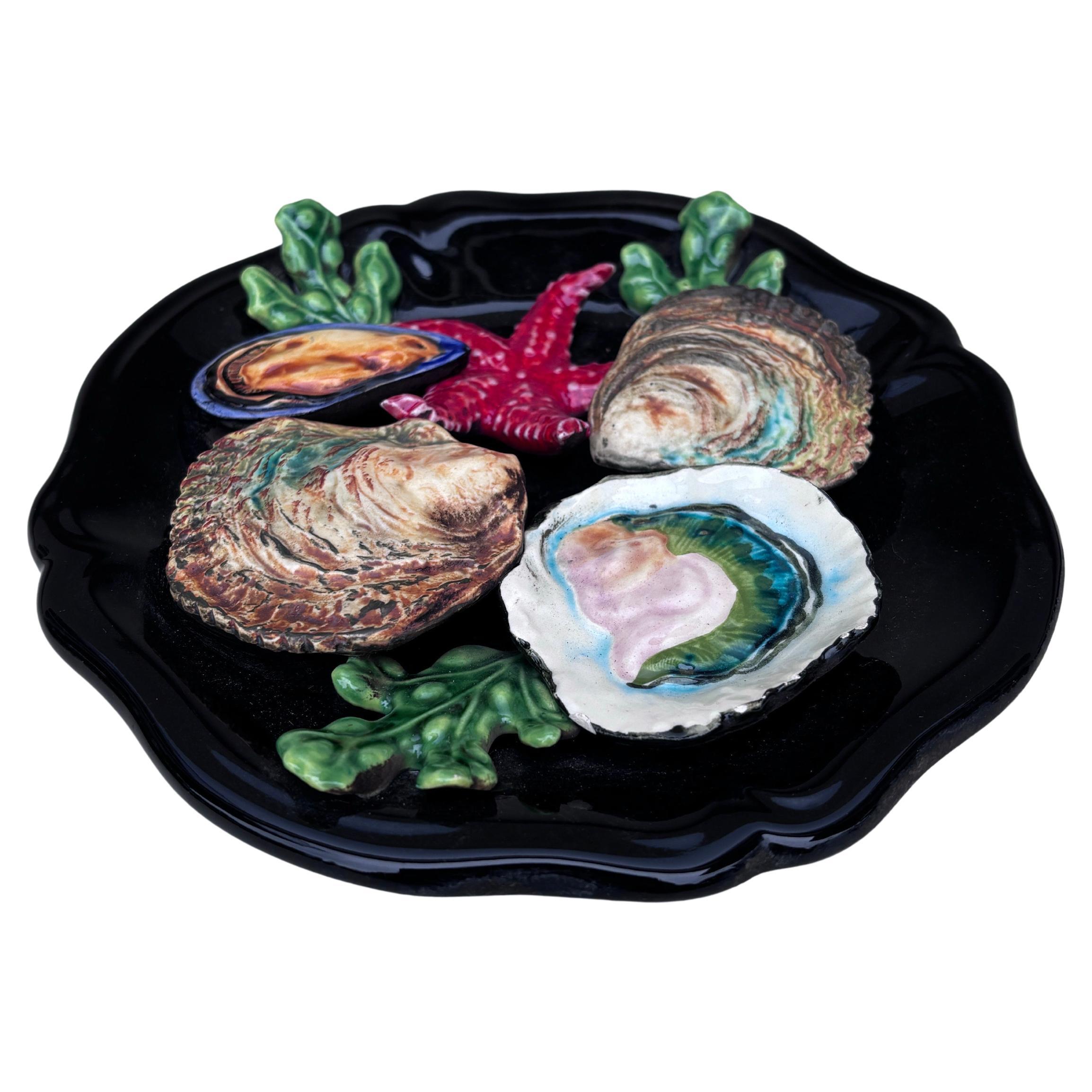 Majolica sealife oysters platter Vallauris, circa 1950.
High relief of seaweeds, starfish , oysters , mussel
Nautical style.
8.3 inches diameter 
 
