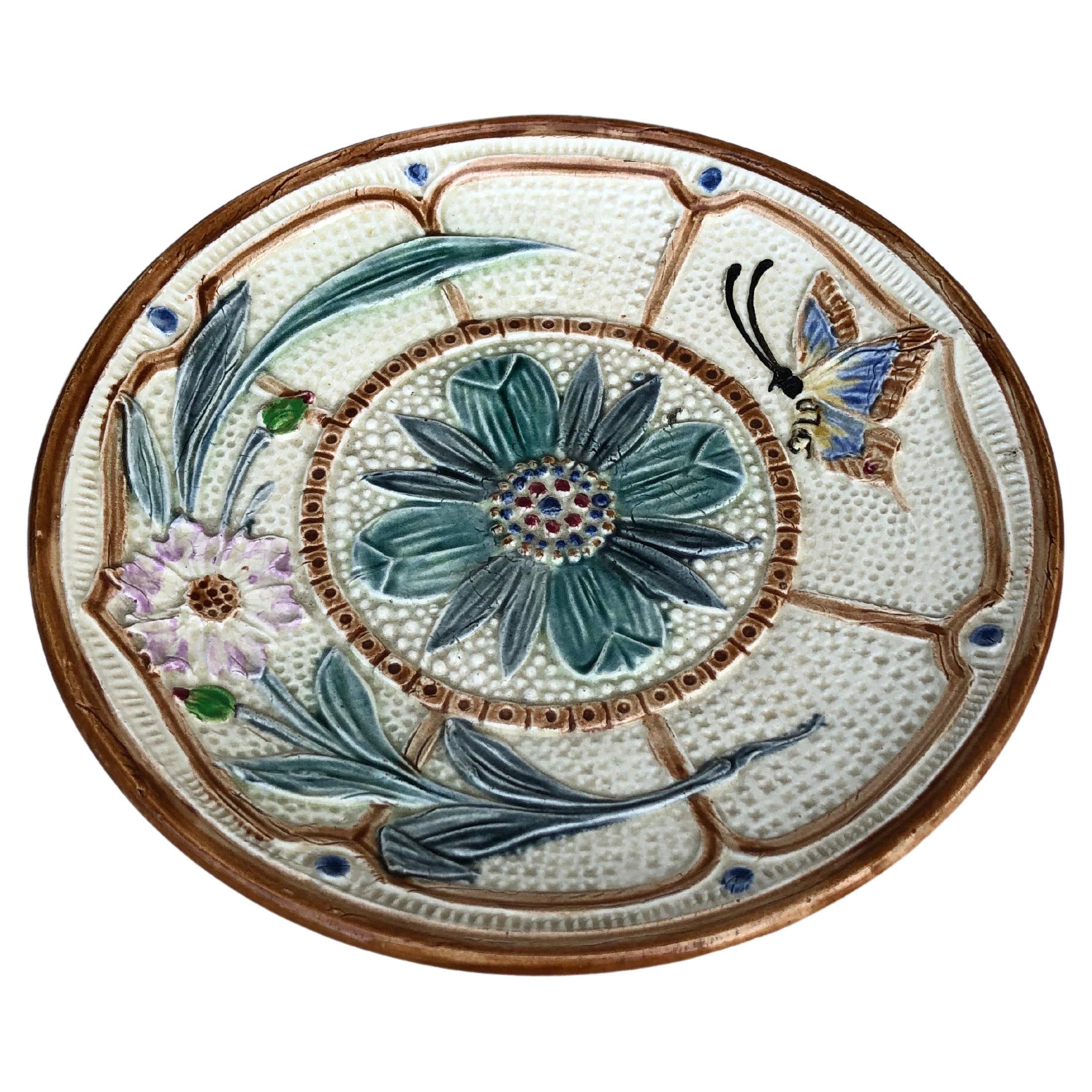 Assiette à fleurs et papillons en majolique Wasmuel vers 1890.