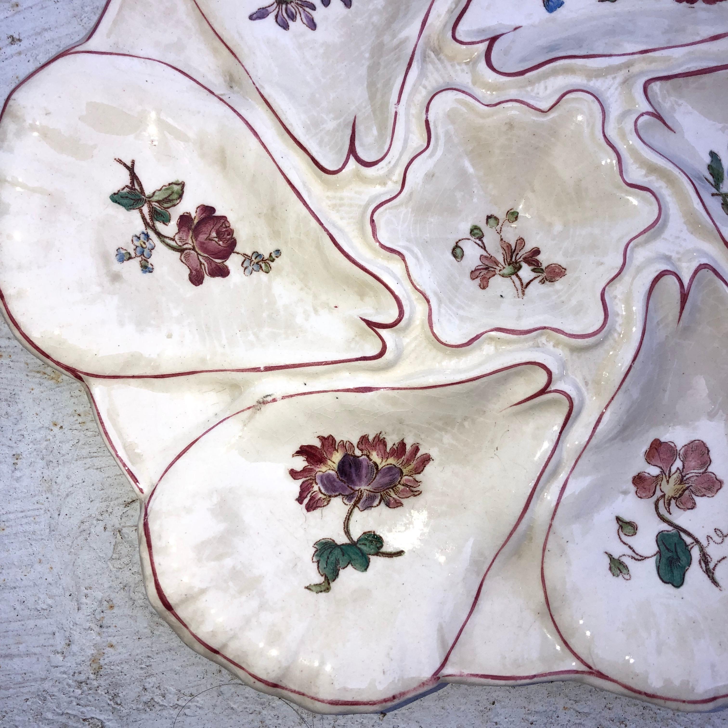 Majolica oyster plate with different flowers on each shells, circa 1900 signed Longchamp.
  