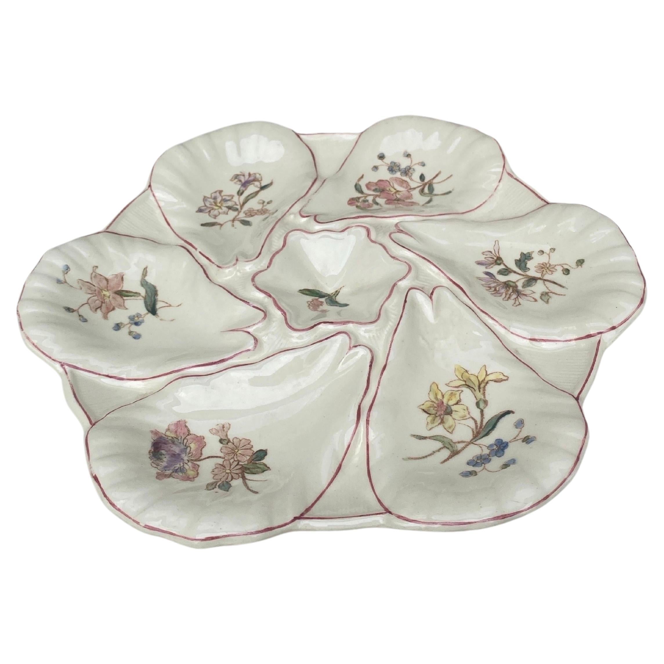 Majolica oyster plate with different flowers on each shells, circa 1900 signed Longchamp.
 