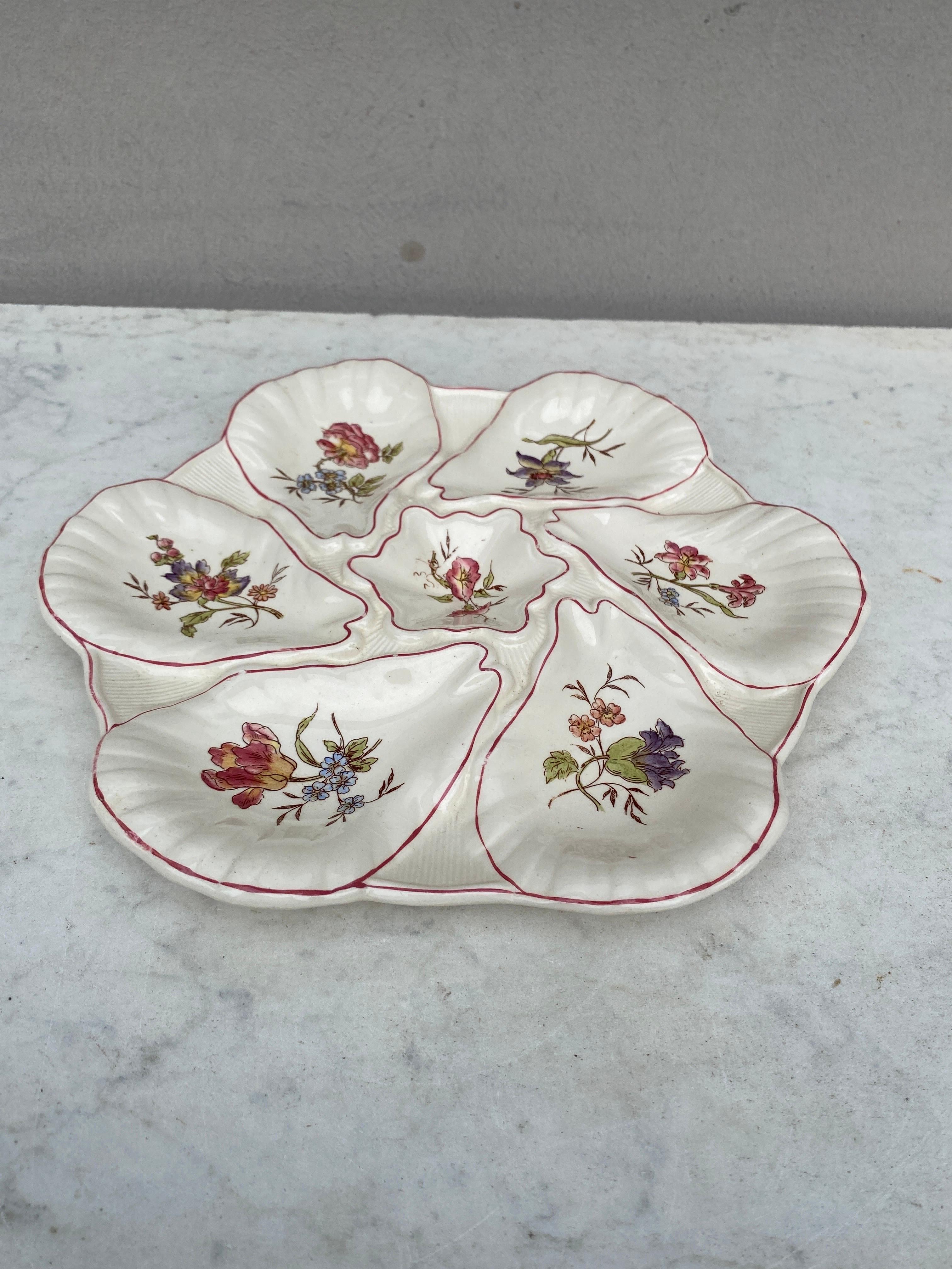 Majolica oyster plate with different flowers on each shells, circa 1900 signed Longchamp.
 
