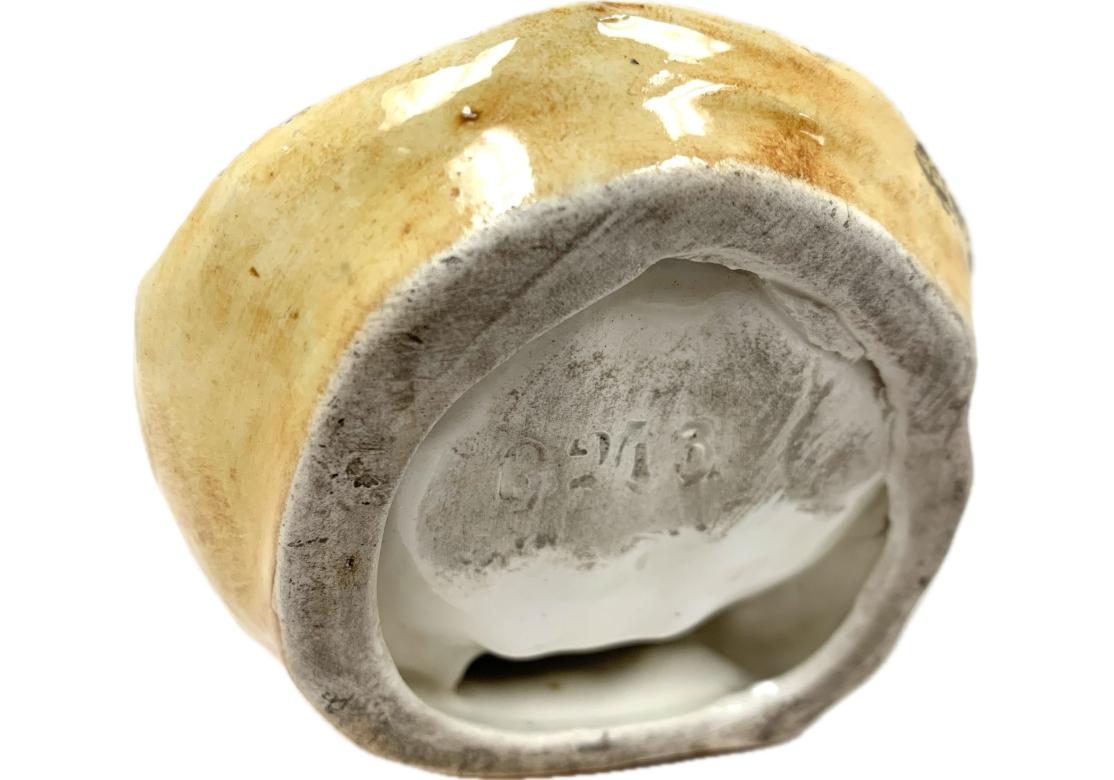 Grenouille anthropomorphe en majolique portant une queue de chemise, perchée au sommet d'un plat en forme de coquillage. Le plat comporte des chiffres indistincts incisés sous la base.

Dimensions : 3 1/2