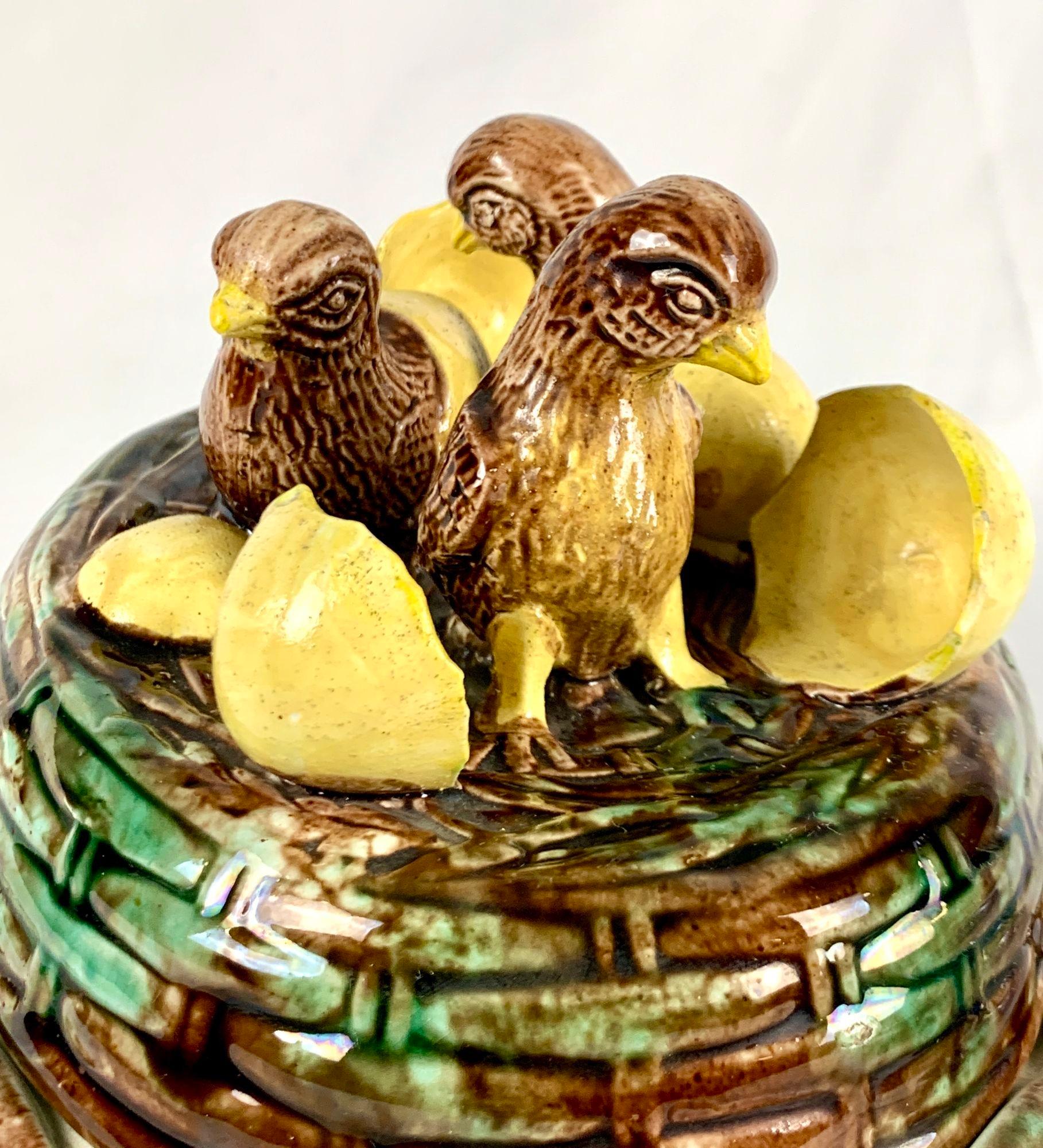 The cover of this majolica game pie dish shows three newly hatched baby chicks emerging from their shells.
The chicks are standing tall and proud.
The brown color of the baby chicks creates a beautiful contrast with the yellow shells and the brown