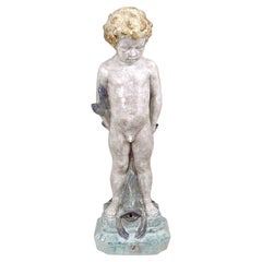 Figura de jardín de mayólica Figura de un niño con un pez como figura o para una fuente